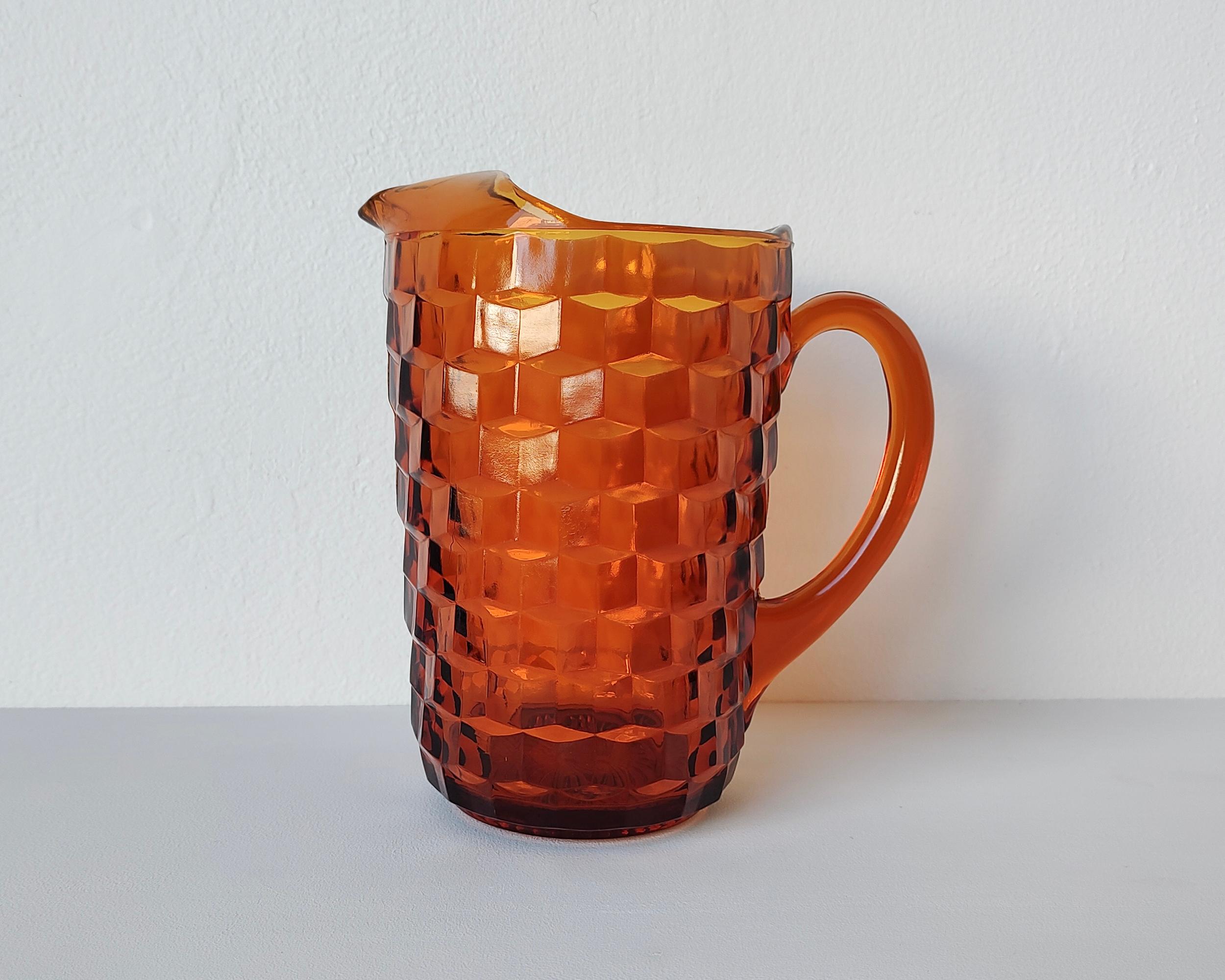 Beautiful vintage thick glass pitcher. Deep orange-umber color with textured geometric design. No chips or cracks.

5.25