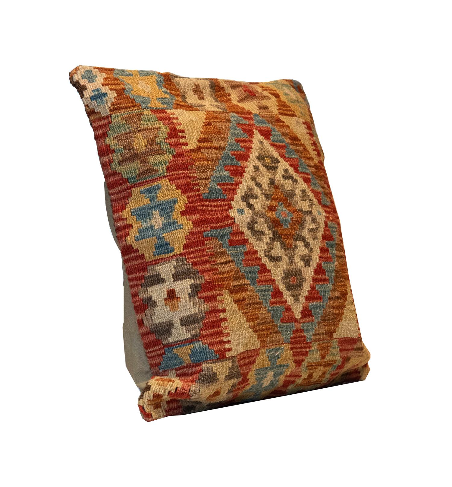 This simple cushion has been woven by hand using traditional kilim weaving techniques with hand-spun wool. The design features a conventional afghan geometric pattern, symmetrically woven with sophistication. This rustic cushion is a great piece to