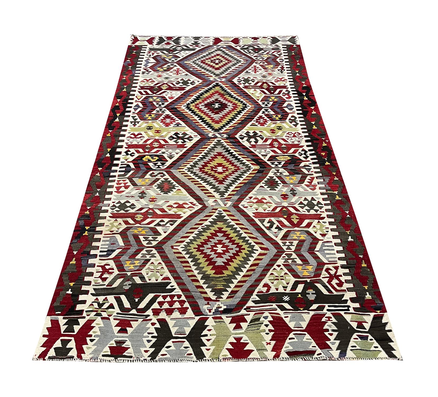 This antique geometric rug is an excellent example of rugs constructed in Turkey In the 1940s. The design features a traditional geometric pattern with four large daimond medallions and a bold enclosing motif background and border. It features