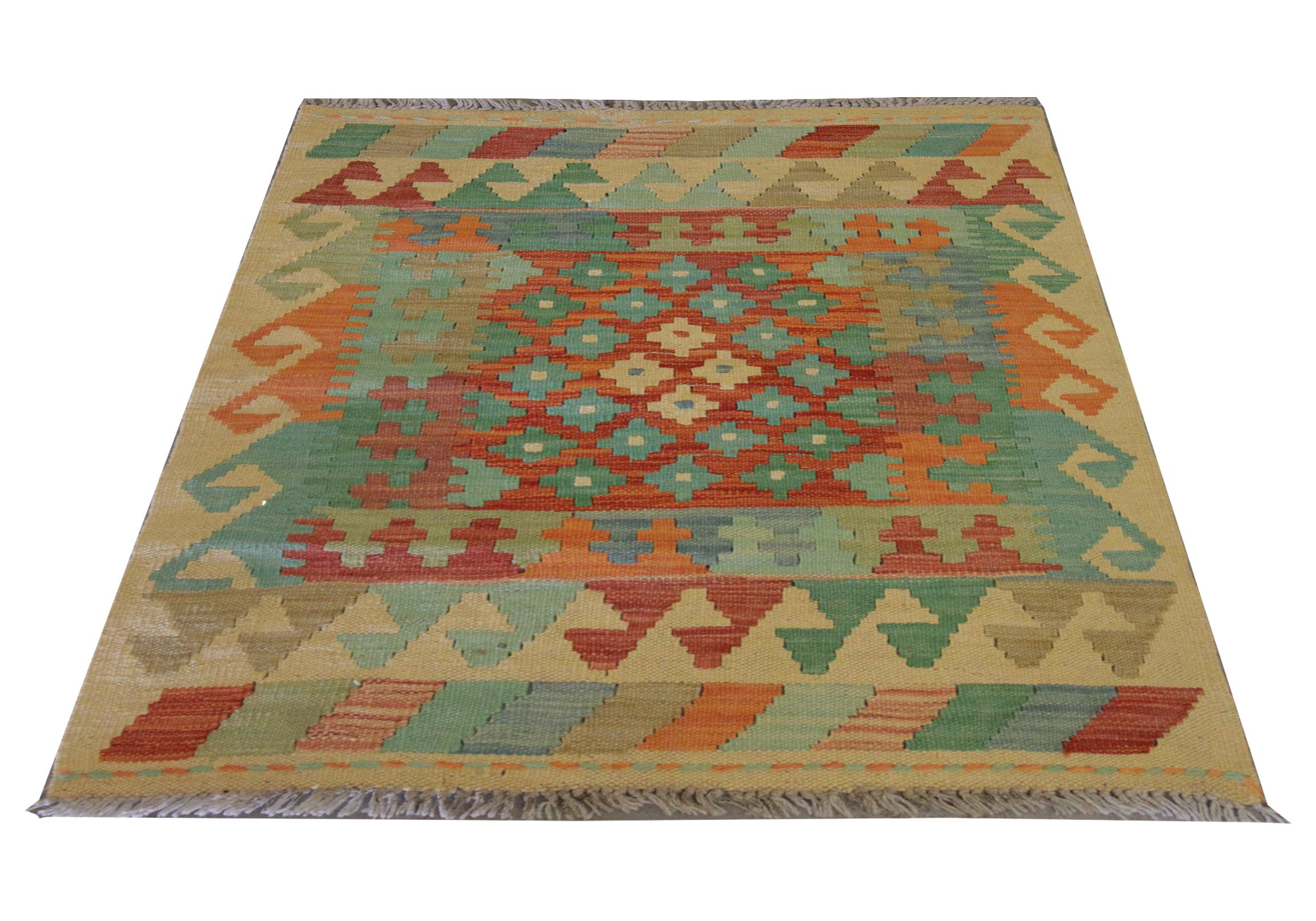 This small kilim rug is a new traditional Afghan kilim woven by hand in the early 21st century. The design features a bold geometric pattern with a layered border woven in green, orange and cream colours. The colour palette and design featured in