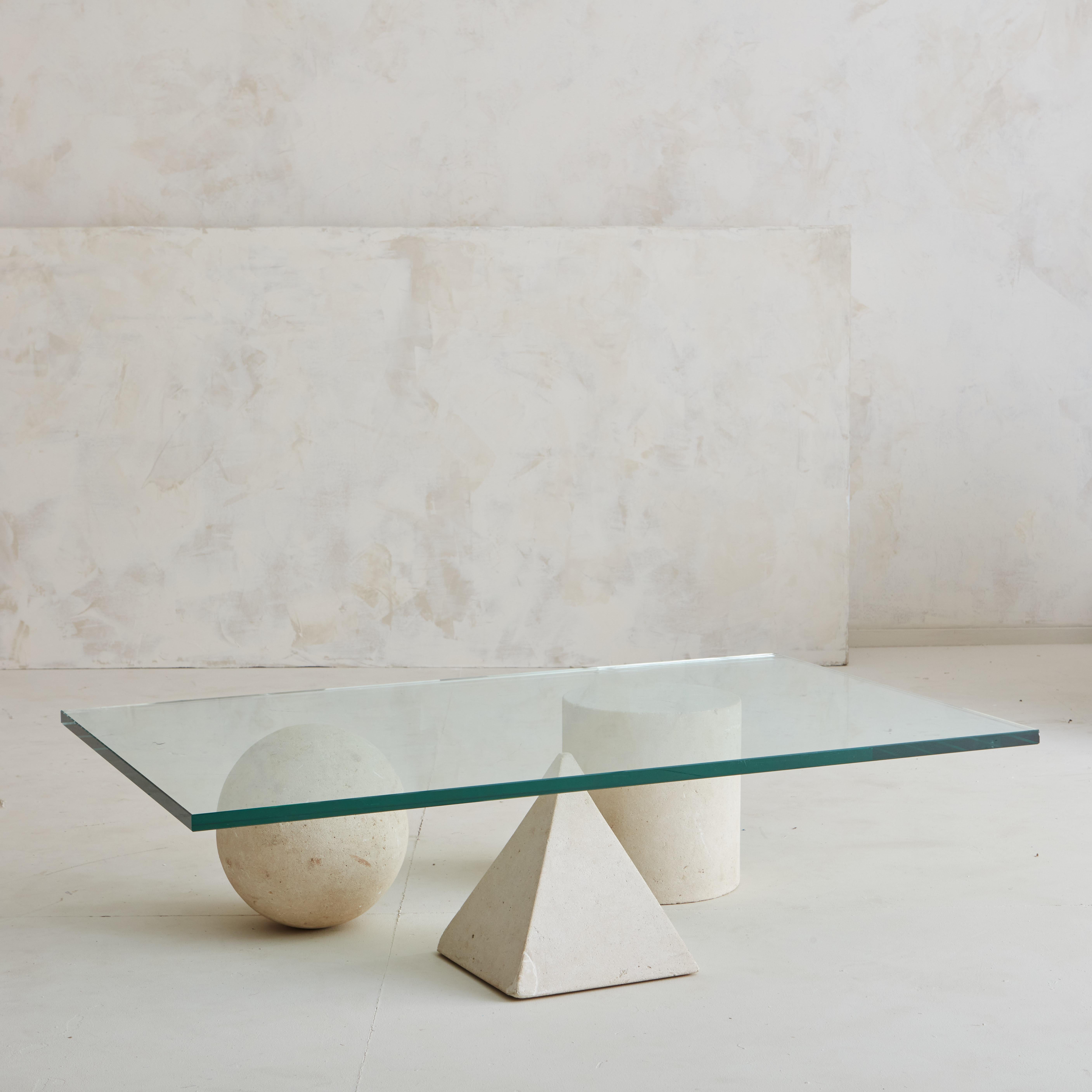 A fantastic vintage coffee table in the manner of Massimo Vignelli. The stone shapes are a honed limestone and each measure 9”H and is finished with a glass top that measures 43” x 27.25”W. This was sourced in the South of France and is circa 1980s.