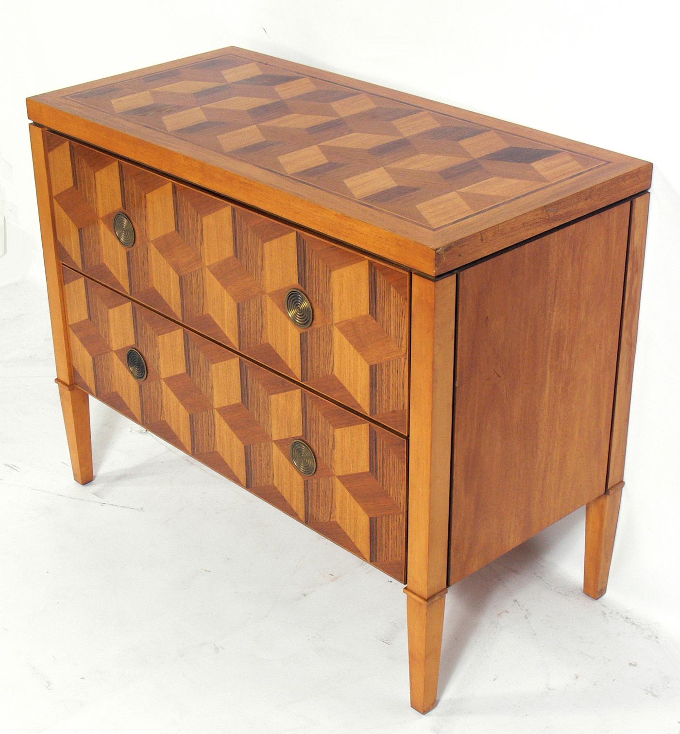 Geometric marquetry chest by Baker, American, circa 1990s. This piece has outstanding geometric marquetry that looks different from every angle. It is a versatile size and can be used as a media cabinet or credenza in a living area, or as a chest or