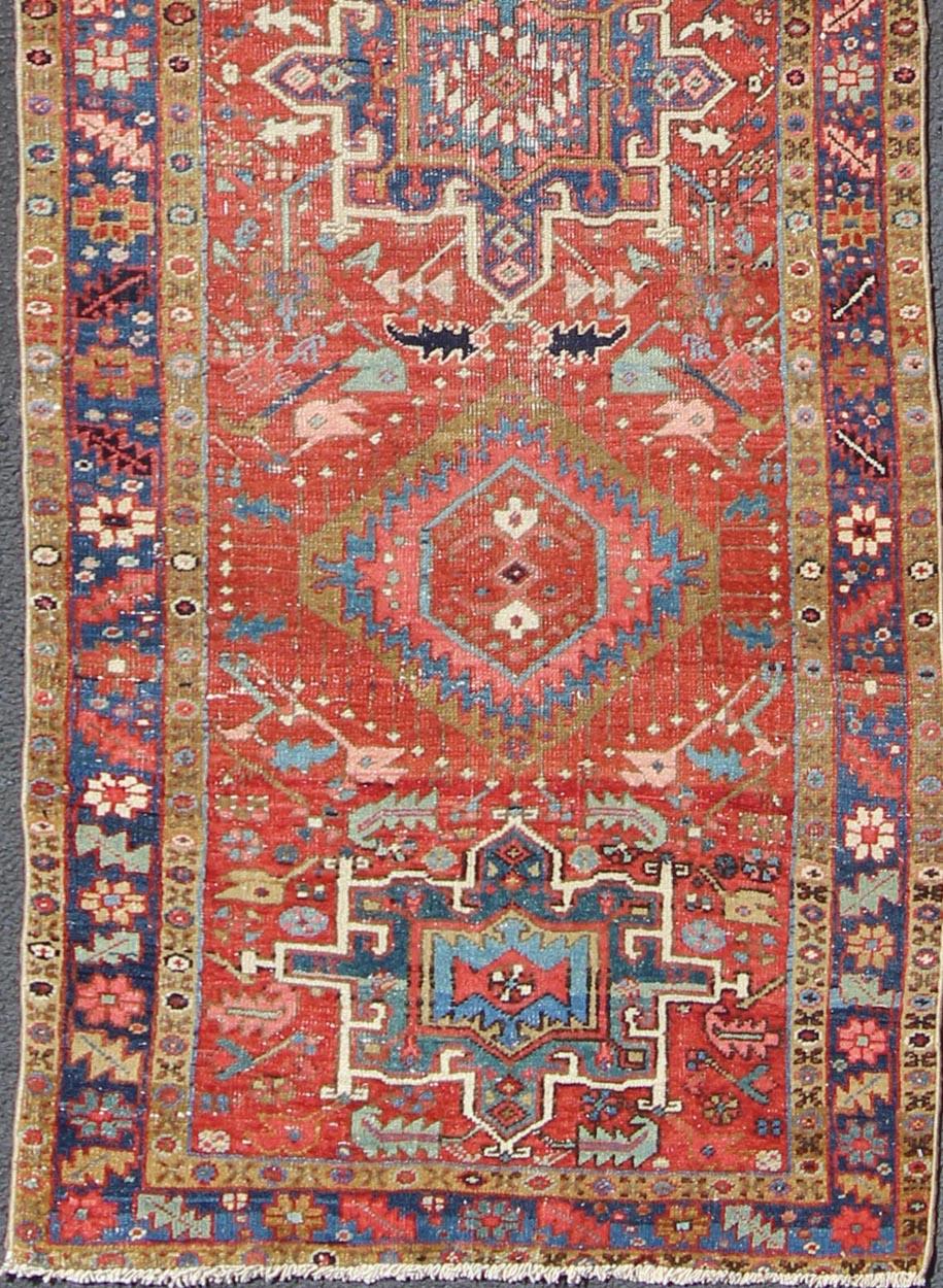 Heriz Persian antique rug with sub-geometric motifs and six medallions in colorful Tones, rug gng-4770, country of origin / type: Iran / Heriz, circa 1920

This antique Persian Heriz runner, from northwest Iran, displays a geometric medallion