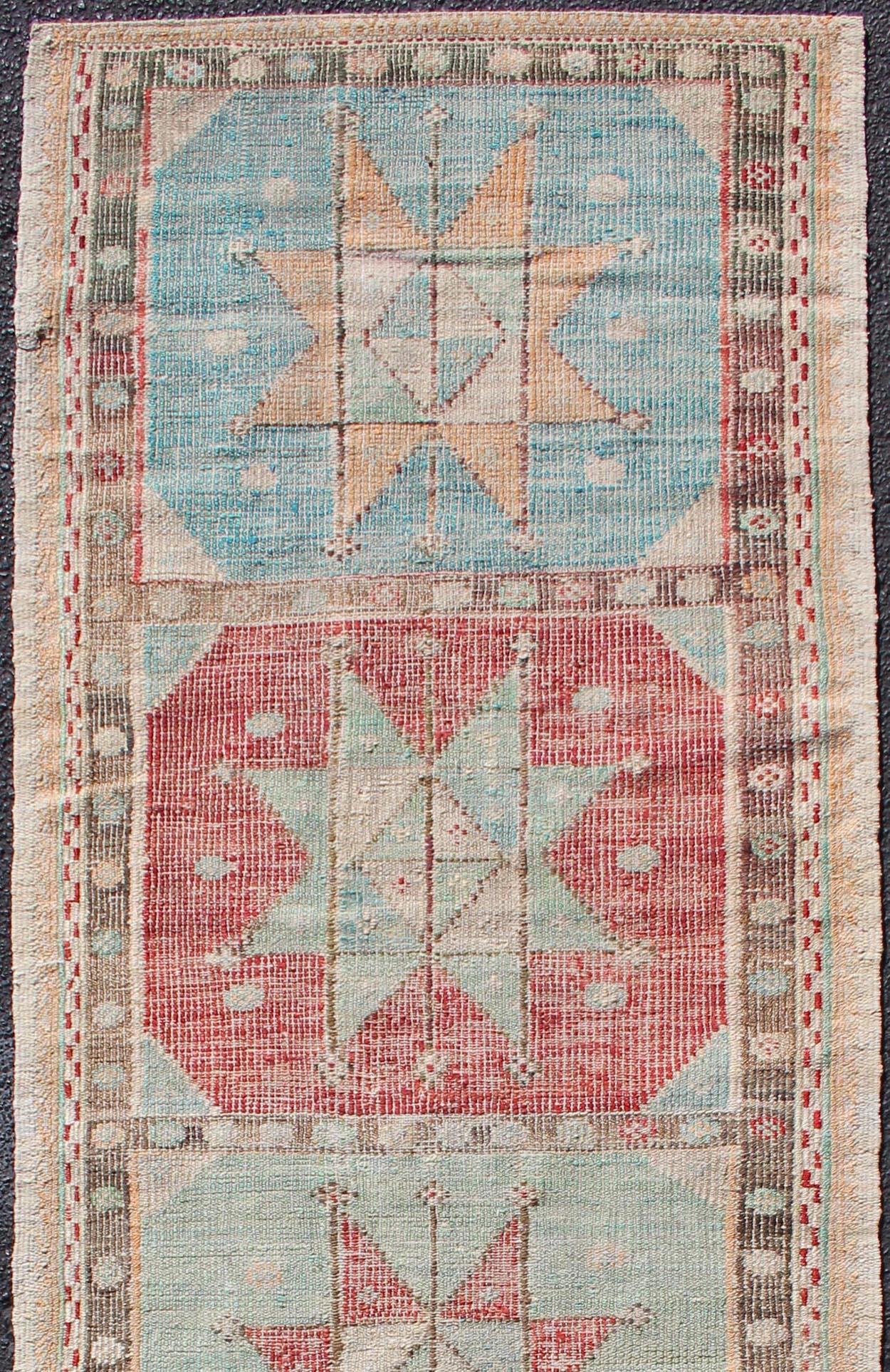 Turkish Kilim vintage carpet in light blue, green, ivory, red and cream, rug en-176957, country of origin / type: Turkey / Kilim, circa 1950

This Embroidered Kilim rug, Jajim, from Turkey features geometric medallion design of various geometric