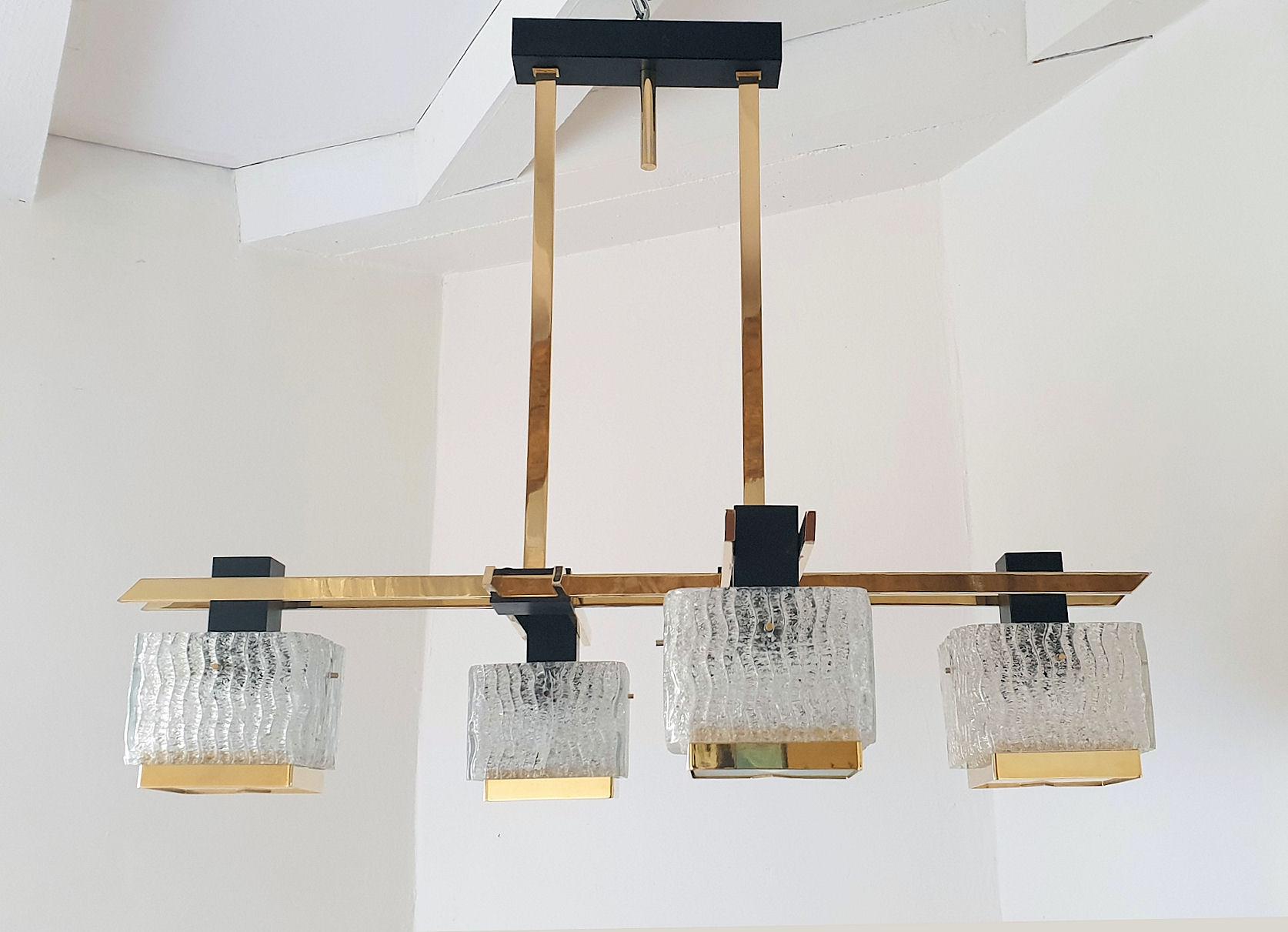 Geometric Mid-Century Modern chandelier, by Maison Arlus, France, 1960s.
Made of a quality brass frame, with black enamel metal elements and thick textured glass squares, nesting the light. 
The chandelier has 4 lights, and is rewired.
In good