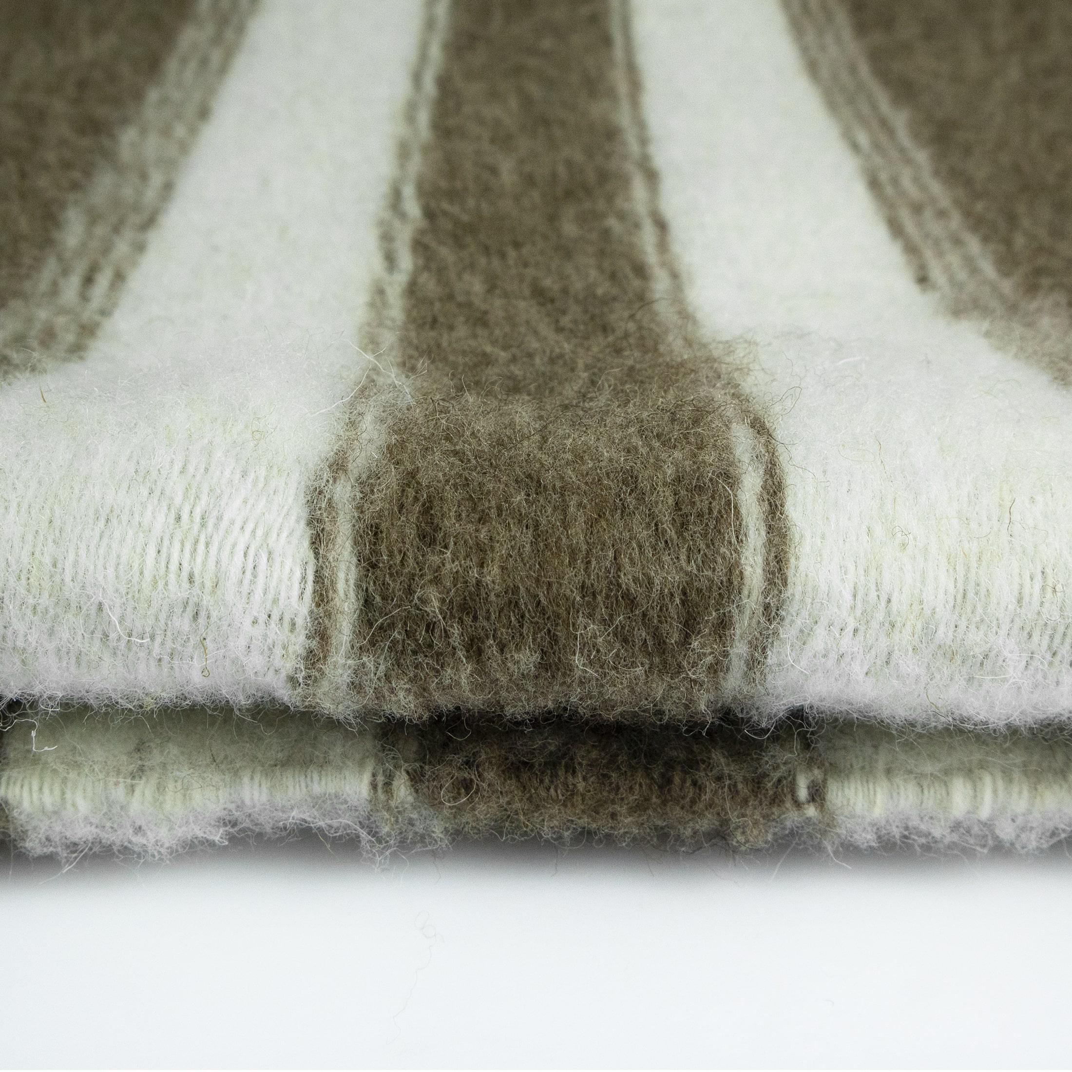Tapis Menizia #04 ist ein handgewebter Teppich mit einem eklektischen Stil aufgrund seiner einzigartigen Farbe, Muster und Textur. 
Dieser rechteckige, handgewebte Teppich hat eine gedämpfte graue Farbpalette und verspielte Streifen, die jedem Raum