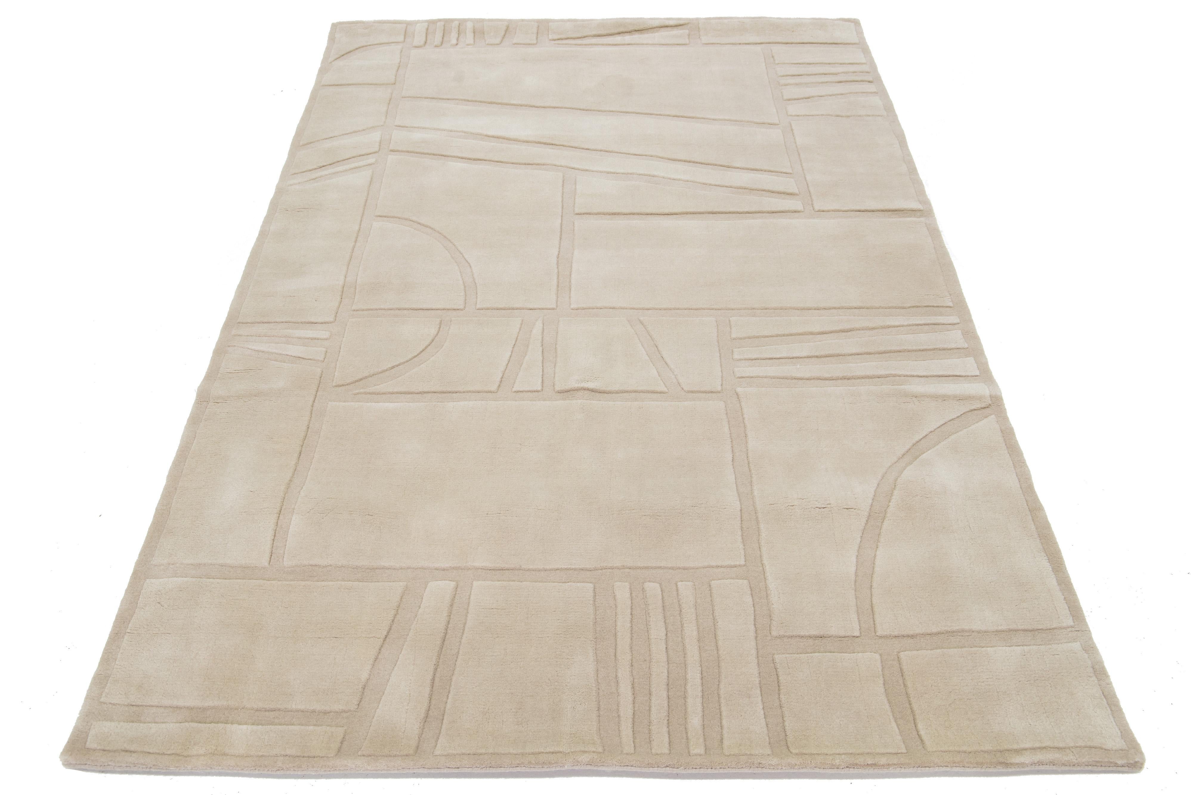 Dieser moderne Teppich ist handgewebt und hat ein modernes, minimalistisches geometrisches Muster. Es hat ein hellbraunes Feld. 

Dieser Teppich misst 5' x 8'.


