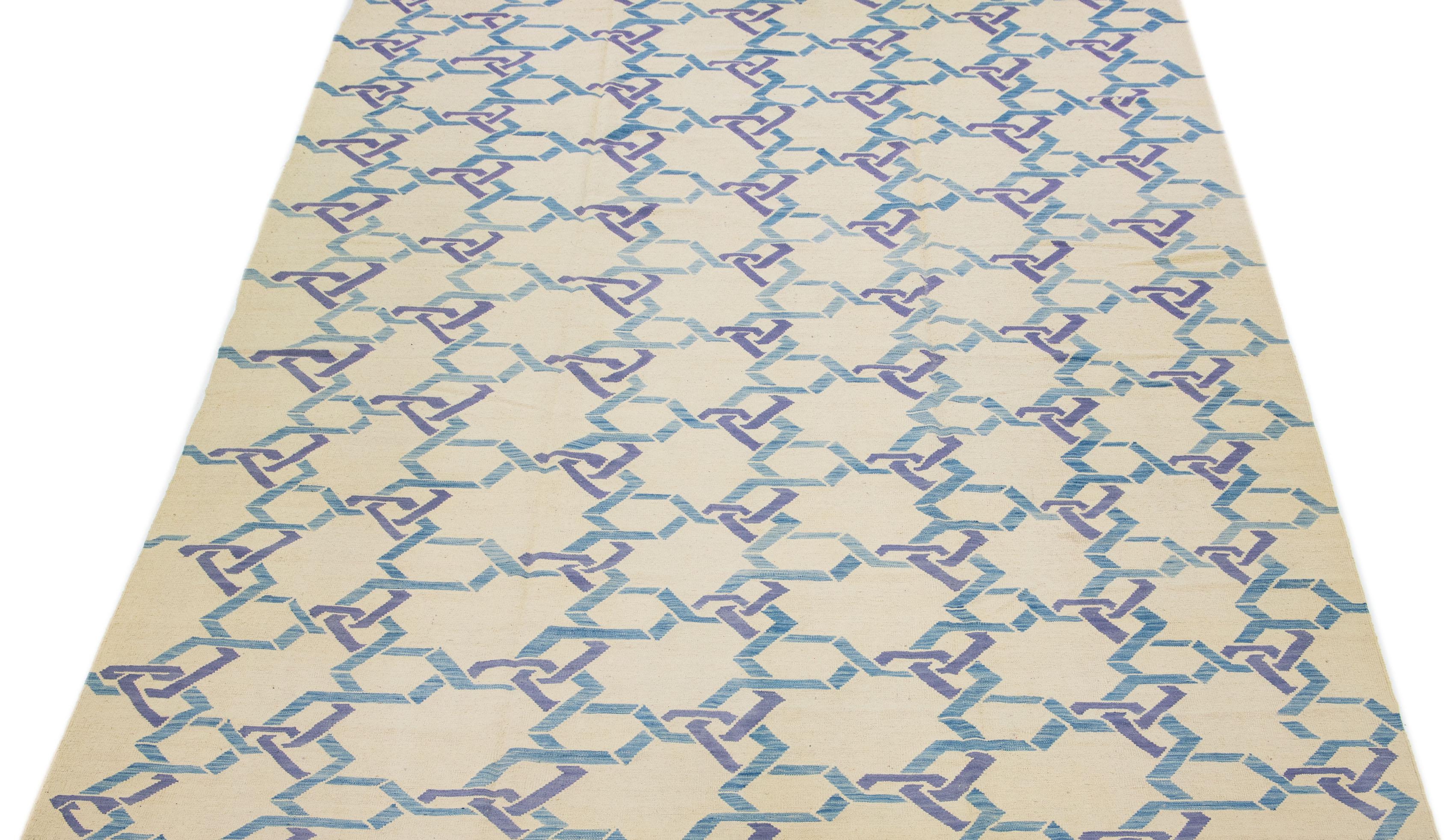 This contemporary Kilim rug is meticulously handwoven with a dominant beige field, highlighted by intricate geometric patterns in shades of blue, providing subtle yet elegant accents.

This rug measures 10' x 13'8
