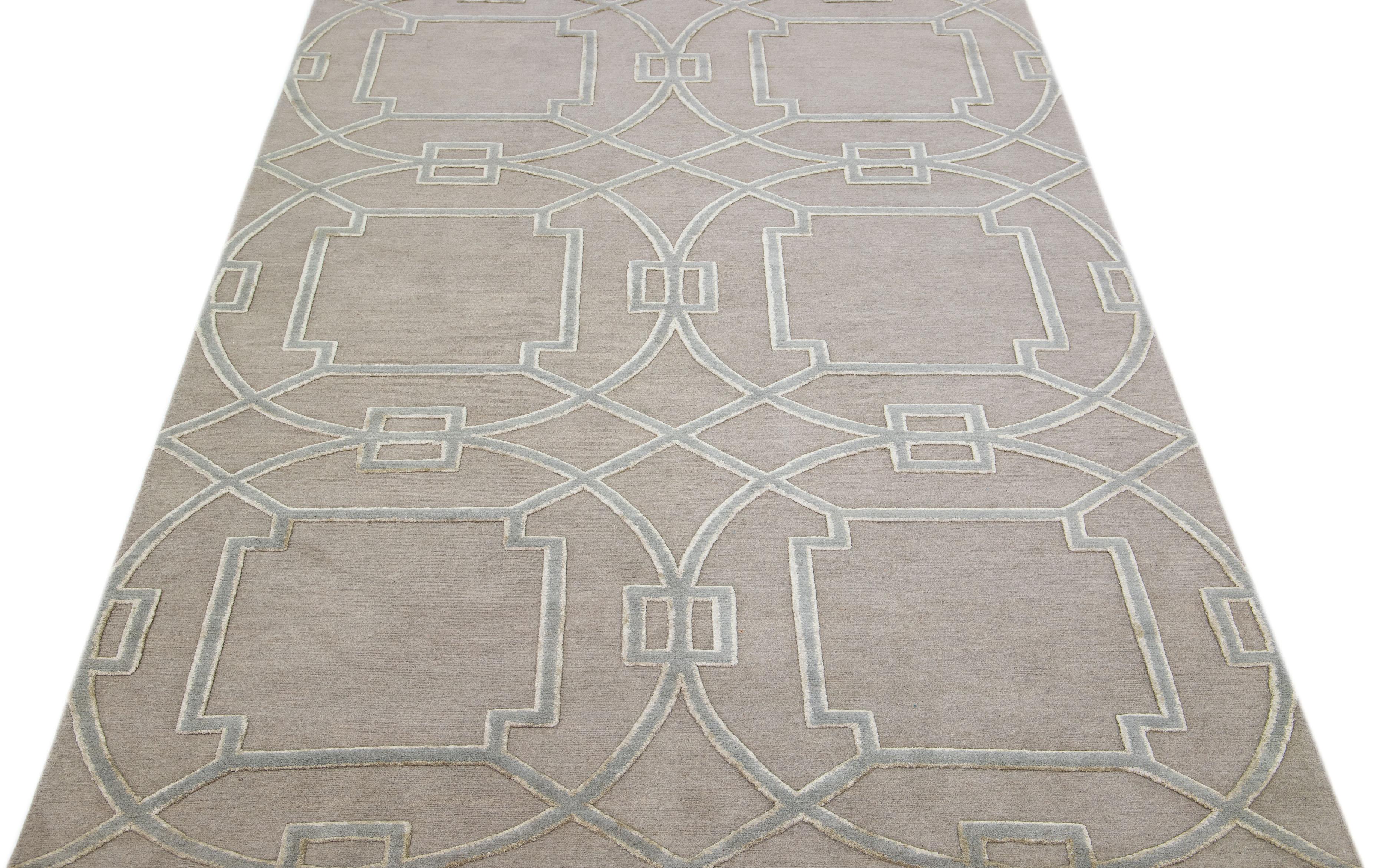 Meticulously crafted by hand using a blend of silk and wool, this exquisite contemporary rug from Tibet showcases a stunning beige foundation perfectly accentuated by an alluring abstract geometric design in shades of gray.

This rug measures 6' x