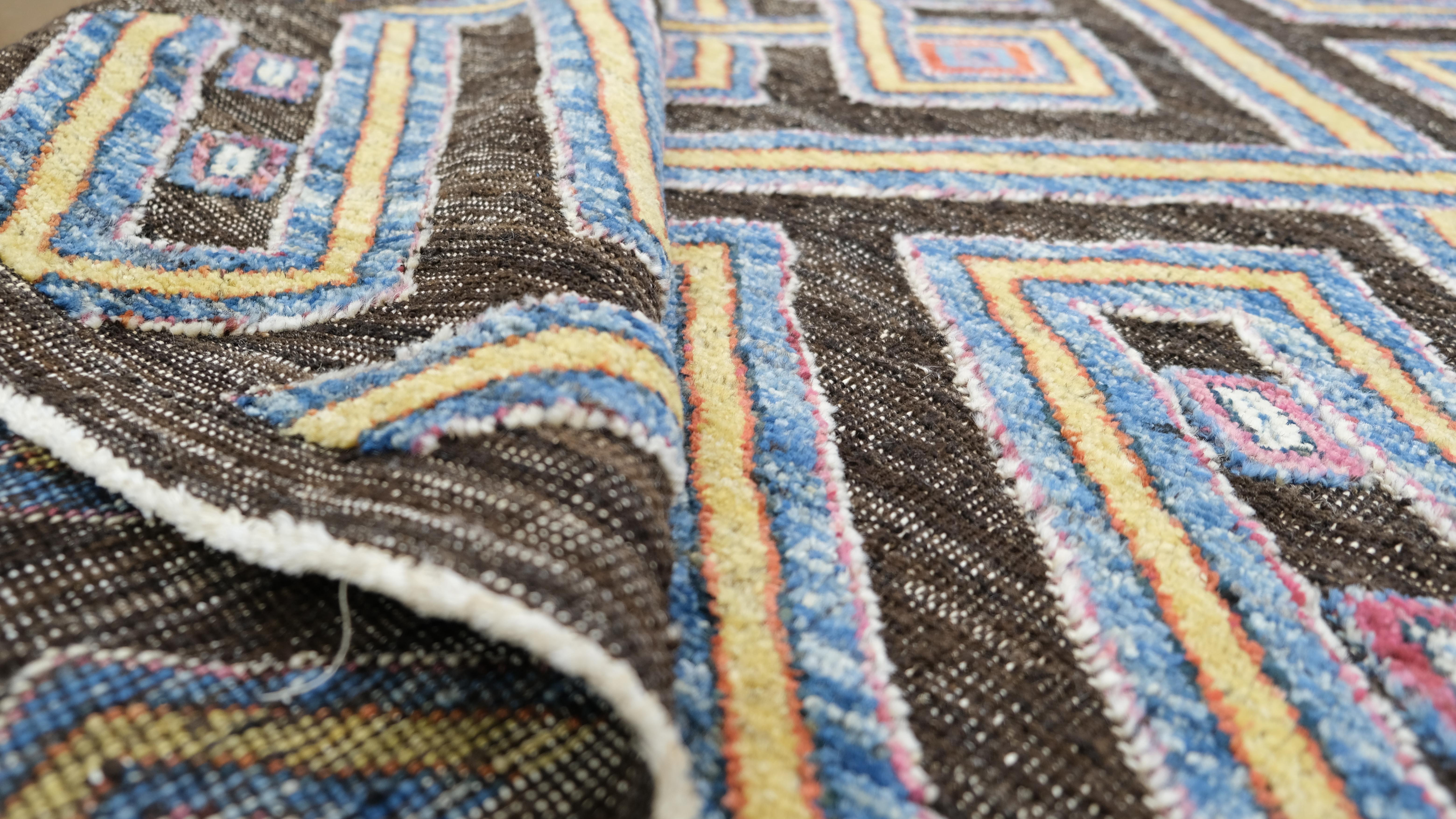 Aggiungi una dichiarazione audace e artistica al tuo spazio con questo tappeto in lana annodato a mano. Caratterizzato da un intricato motivo geometrico a rombi multicolore, questo tappeto offre un'interpretazione contemporanea di motivi