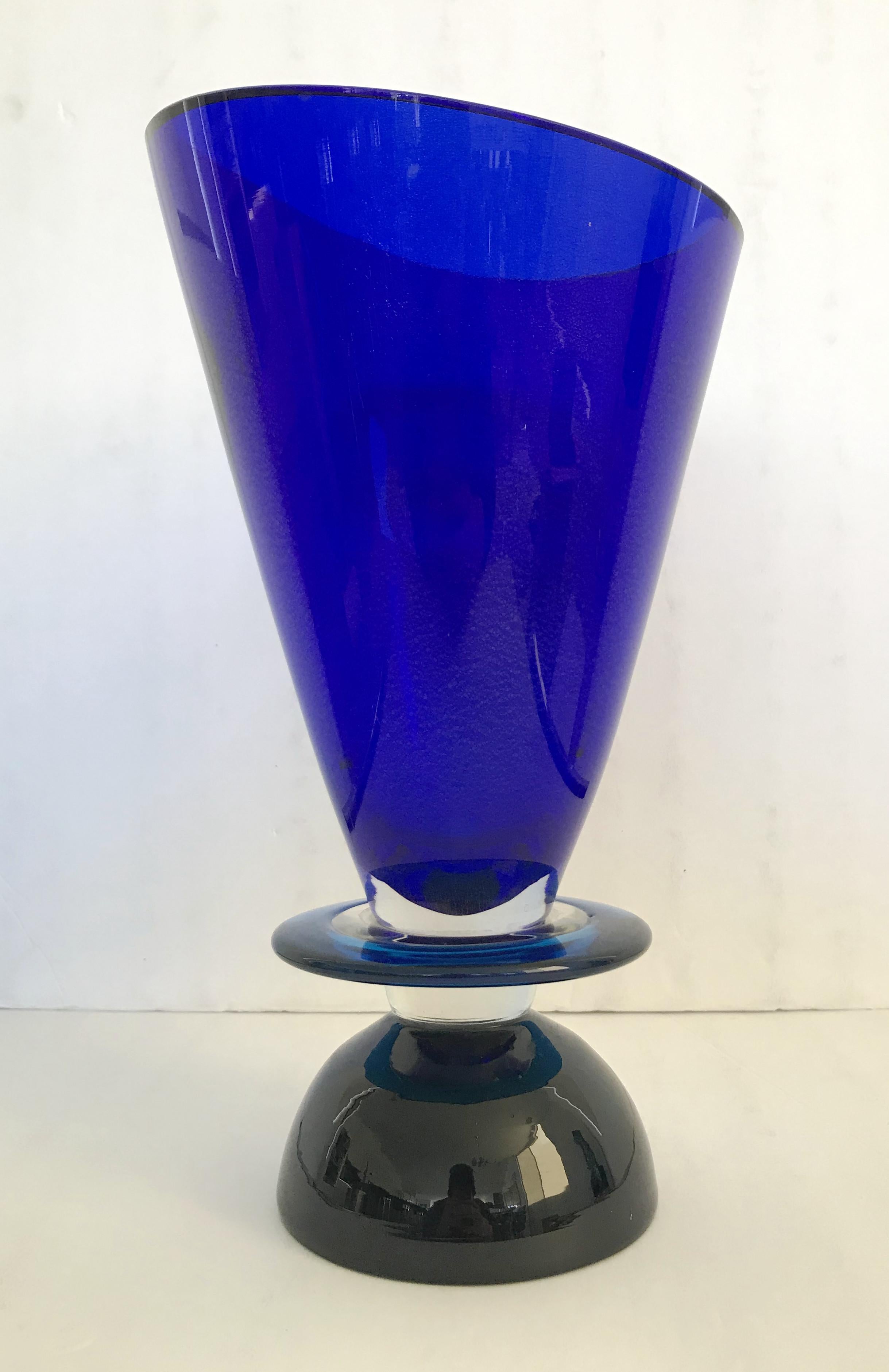 Memphis group inspired Murano glass vase, with a large dark blue cone shaped top infused with silver flecks, a round light blue disk, and a black dome shaped base / Made in Italy in 1994
Measures: height 13 inches, diameter 7.5 inches, base diameter