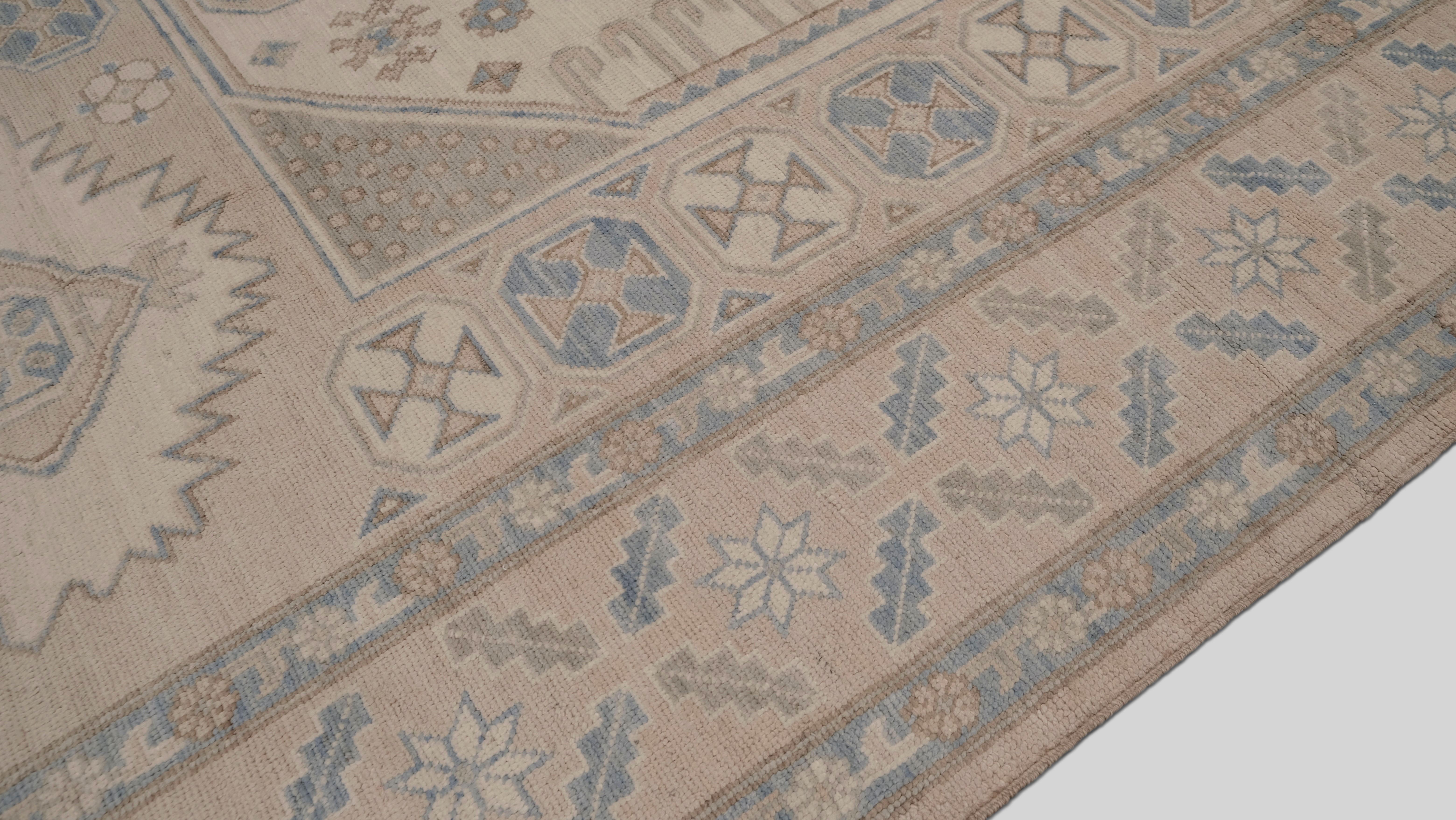 Verwandeln Sie Ihren Wohnbereich mit diesem eleganten, handgeknüpften Wollteppich in zarten Pastelltönen. Mit seinem fesselnden geometrischen Design hebt der Teppich verschlungene Medaillons, symmetrische Muster und eine wunderschön detaillierte
