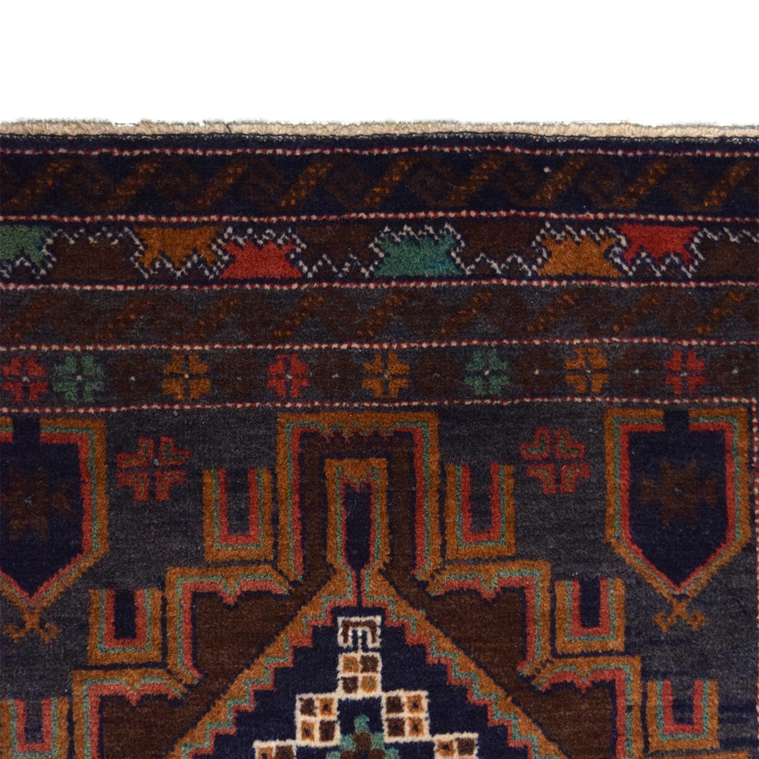 Measuring 3’ x 4’10”, this Persian Balouchi carpet is entirely hand knotted and features a geometric design. The warm shades of blue, red, gold, brown, and green come from the organic vegetable dyes used in the hand-spun wool. Due to the traditional