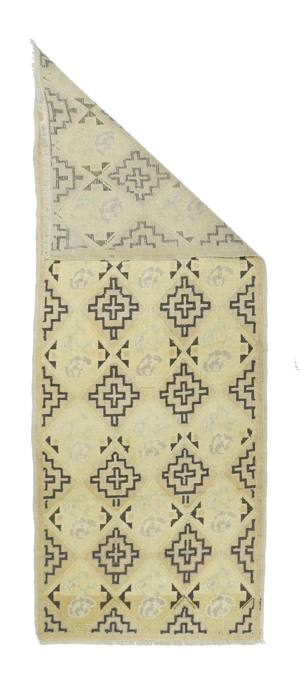 Tappeto geometrico 2'8'' x 7'0''. Questo piccolo tappeto lungo del villaggio anatolico mostra il popolare campo di paglia e panna, questa volta con due colonne centrali e due laterali parziali di croci annidate e a gradini dettagliate in marrone