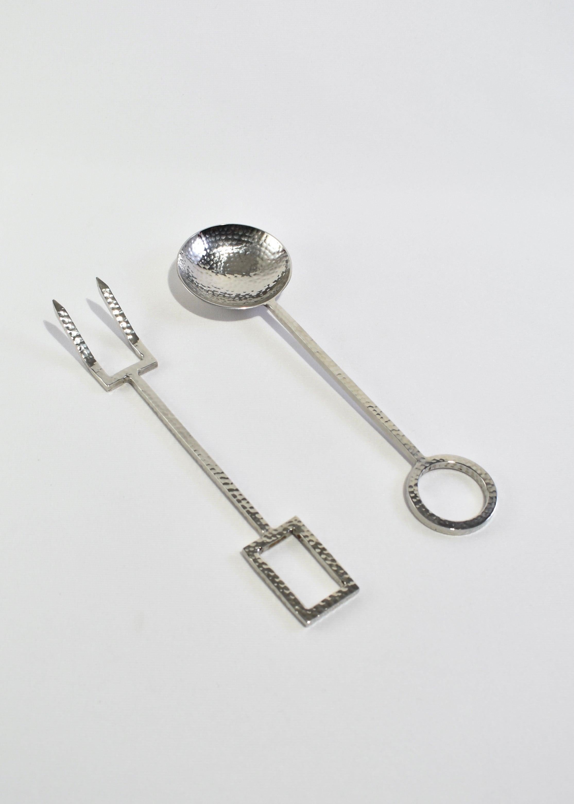 Rare, hammered stainless steel serving set with geometric details. Designed by Michael Aram.
