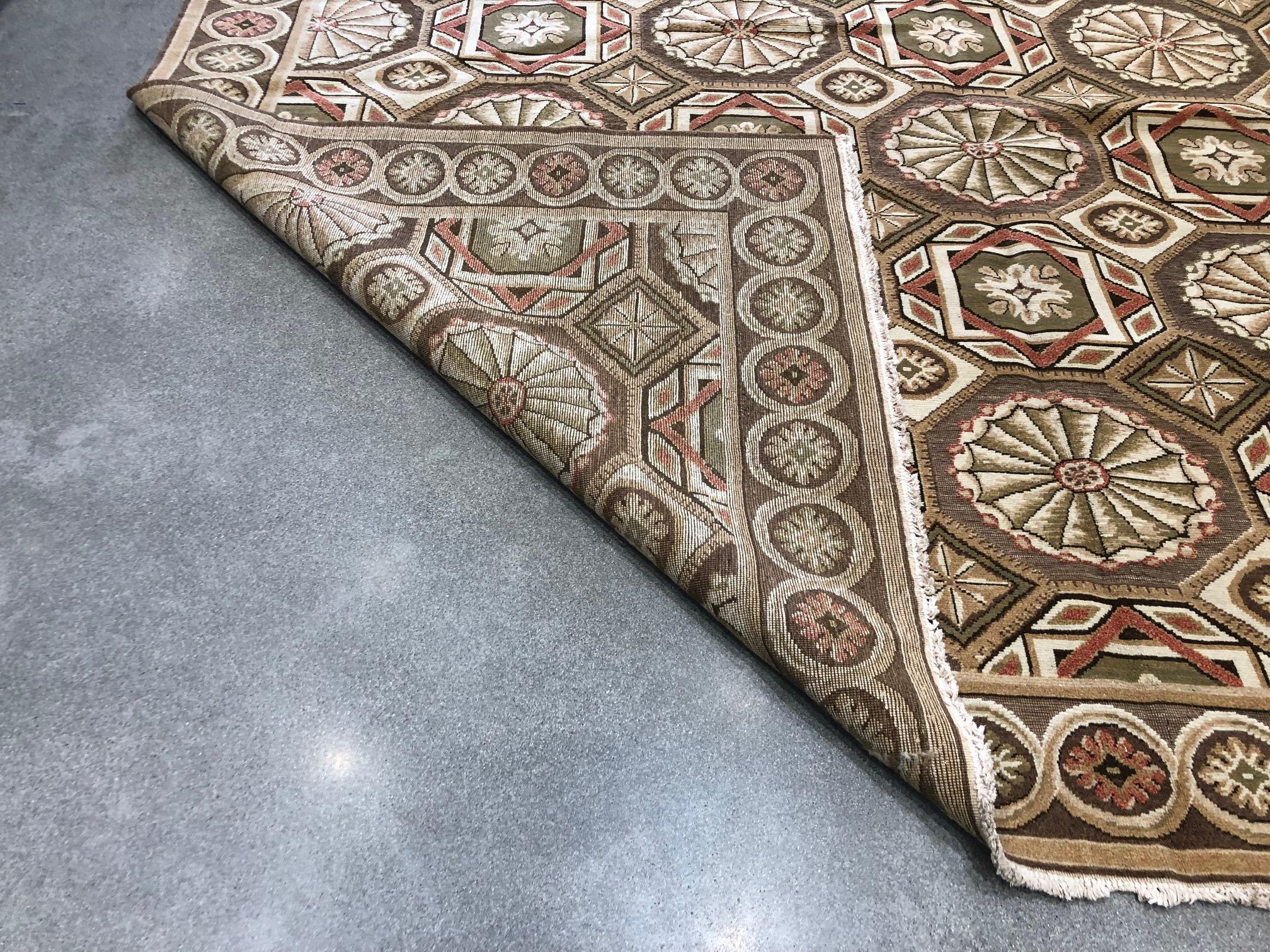 An intriguing pattern and unusual colors combine to create a rug that stands out from the rest. Bold shapes in brown, rust and cream tones in the large centre pane create a kaleidescope effect while starbursts in similar tones line the edges. A