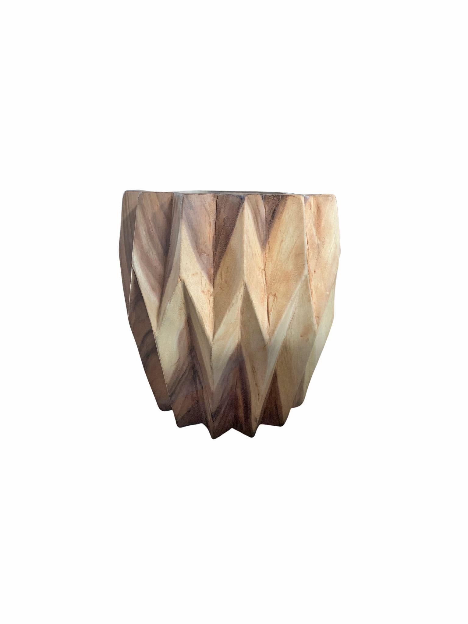 A wonderfully sculptural round side table. Its neutral pigment and subtle wood texture makes it perfect for any space. A uniquely sculptural and versatile piece. This table was crafted from mango wood and was crafted to resemble a work of origami.
