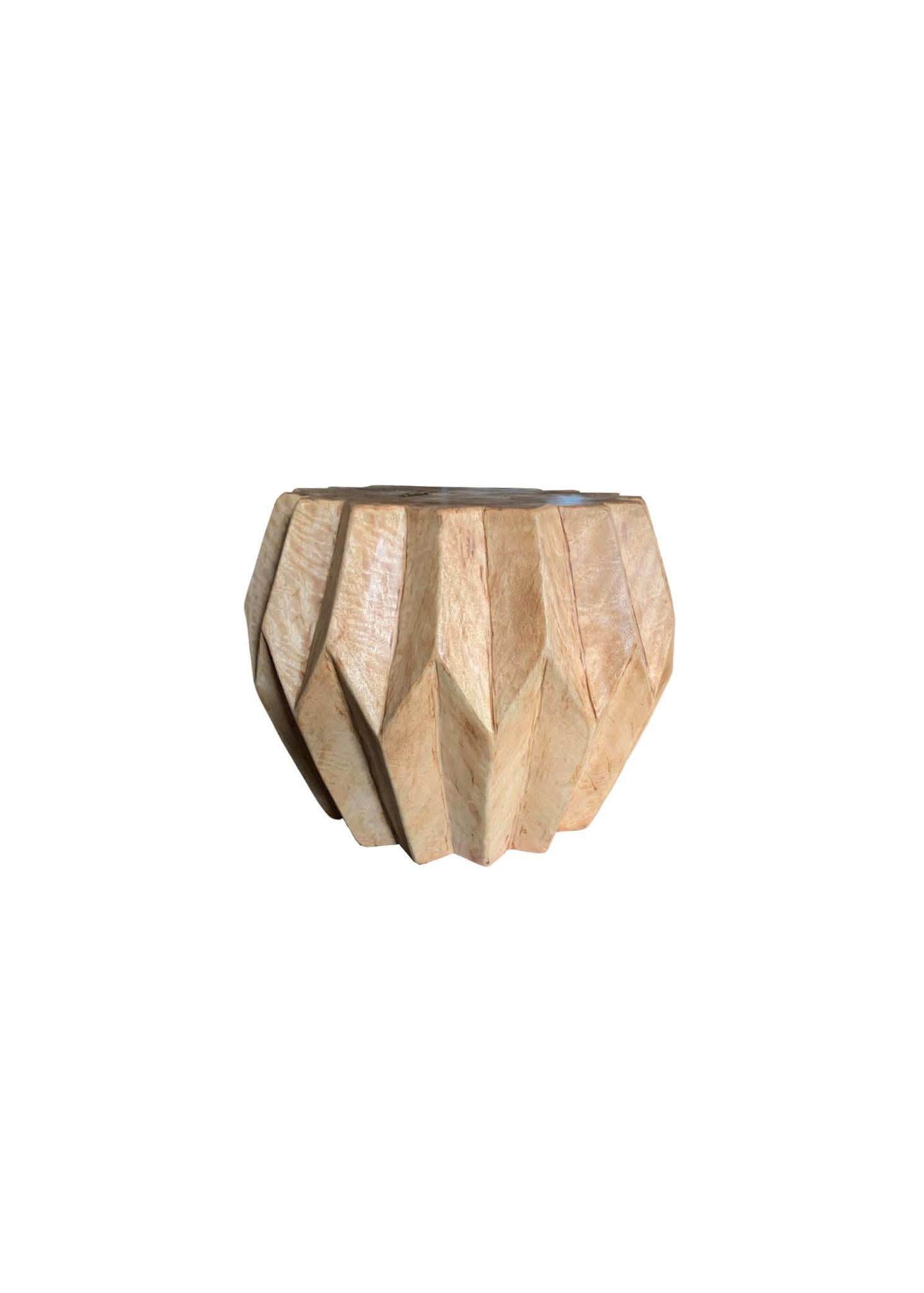 A wonderfully sculptural round side table. Its neutral pigment and subtle wood texture makes it perfect for any space. A uniquely sculptural and versatile piece. This table was crafted from mango wood and was crafted to resemble a work of origami.