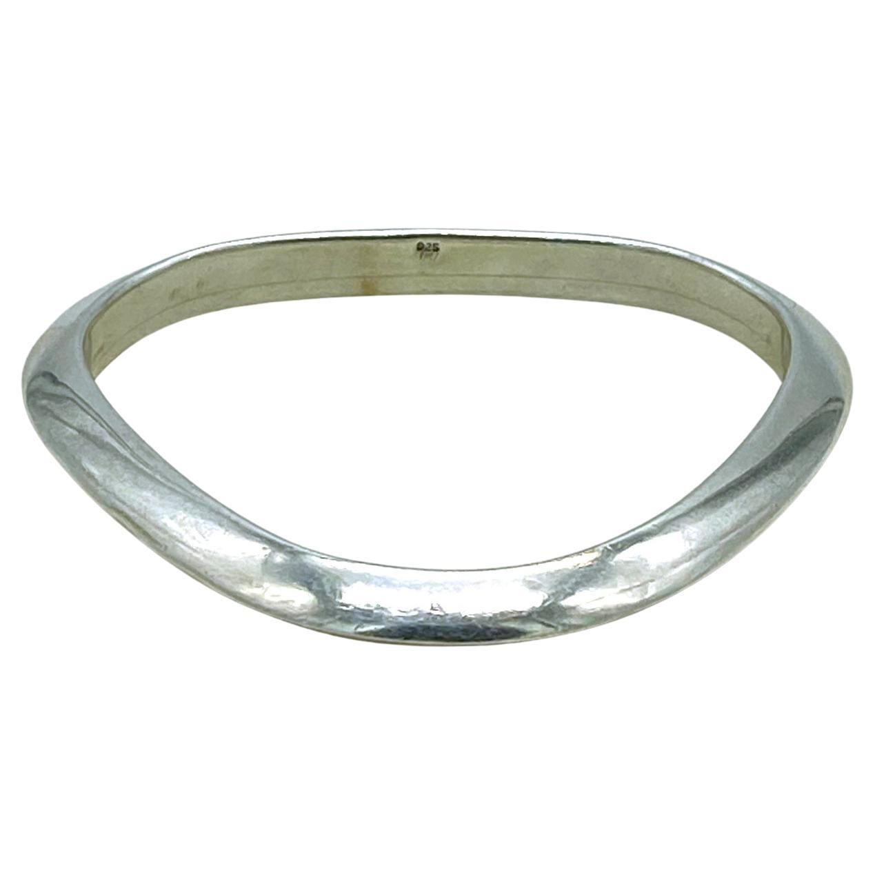 This is a geometric solid sterling silver bangle. This polished bright silver triangle shaped bangle with round corners also has a triangular cross-section. You could have combinations with the other two of the geometric modern bangles in my