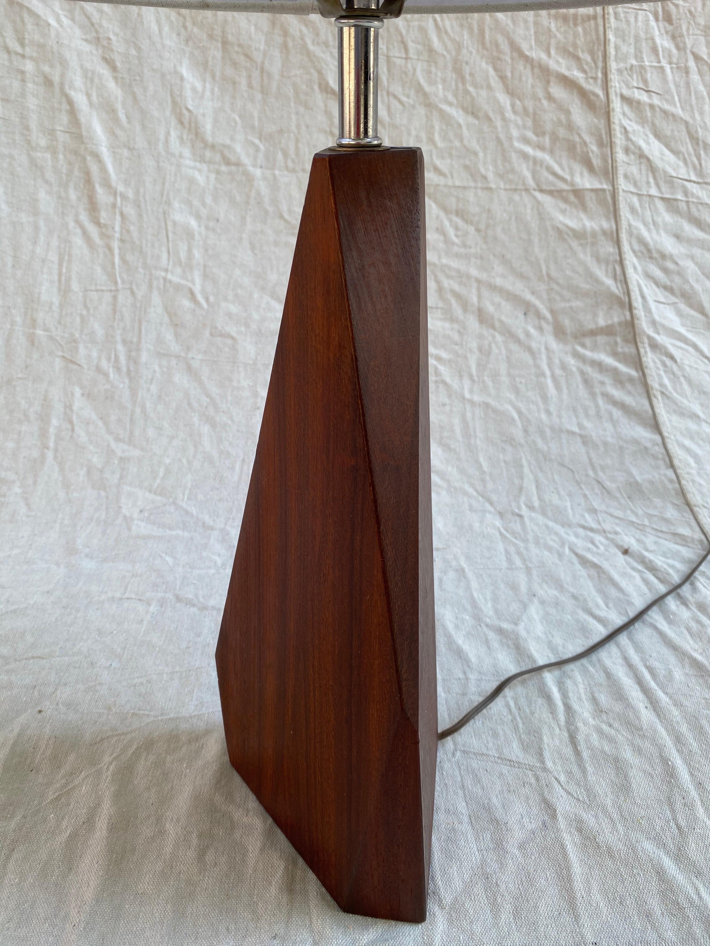 Geometric solid wood table lamp, possibly redwood. Triangular in shape, with partial flat sides. Nice rich color to wood. Wood base is 15.5 tall.