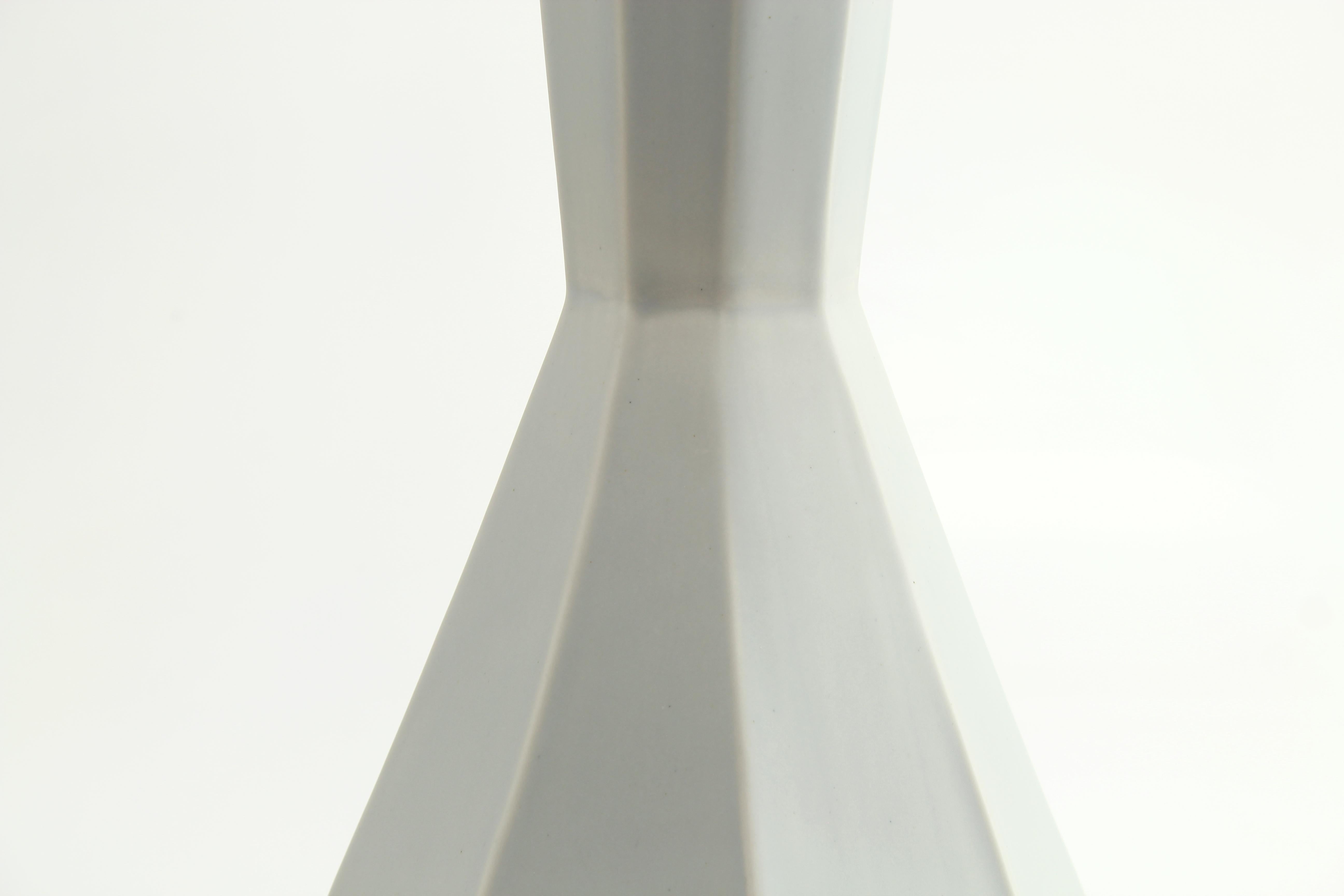 The clean, modern design of the geometric statement vase offers an updated, elegant look to your room with a Mid-Century Modern feel. This one of a kind piece features a matte grey glaze - soft to the touch and easy on the eyes. Add a large