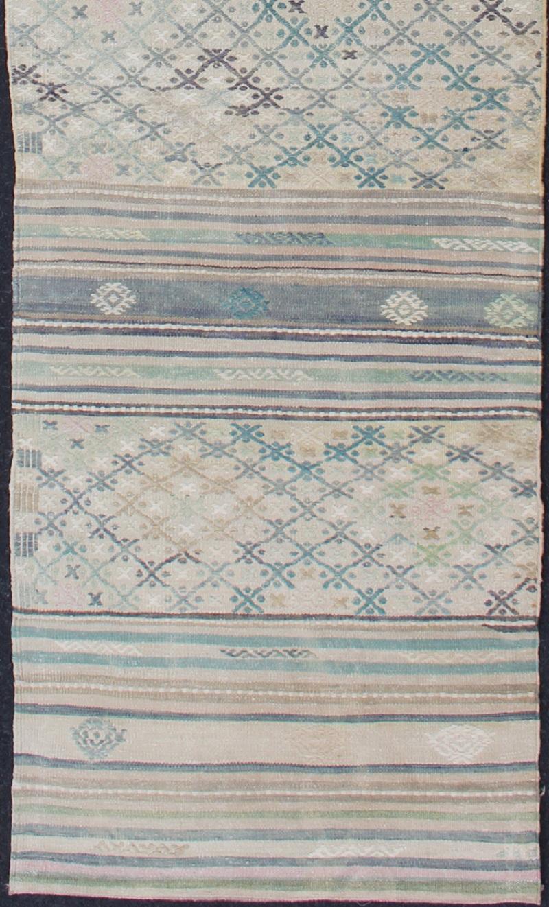 Turkish Kilim vintage carpet in green, ivory, and cream, rug en-176525-2, country of origin / type: Turkey / Kilim, circa 1950

This Kilim rug from Turkey features a striped design of various geometric patterns rendered in shades of green, ivory,