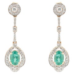 Geometric Style Oval Emerald and Diamond Halo Drop Earrings in 14K Yellow Gold