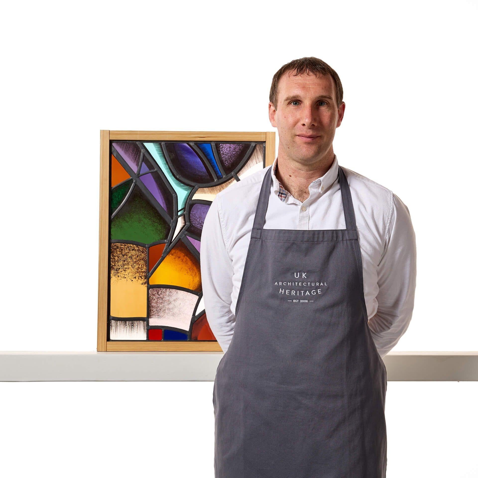 A geometric style stained glass panel by renowned stained glass makers Goddard and Gibbs.

This is abstract modernist stained glass window showcases an unusual style, blending together a range of vivid colours, shapes and patterns.

This
