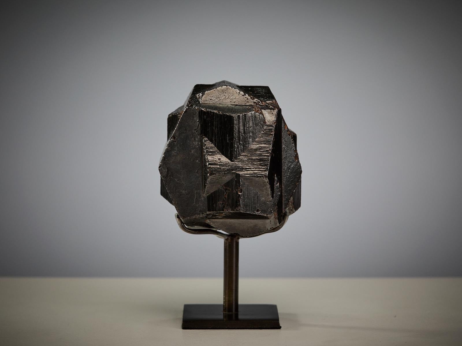 A fascinating and sculptural specimen from Colombia, where limonite has replaced the original pyrite crystal while perfectly preserving its sharp geometry. The intergrown cubic forms are so harmoniously unified that they create the appearance of a