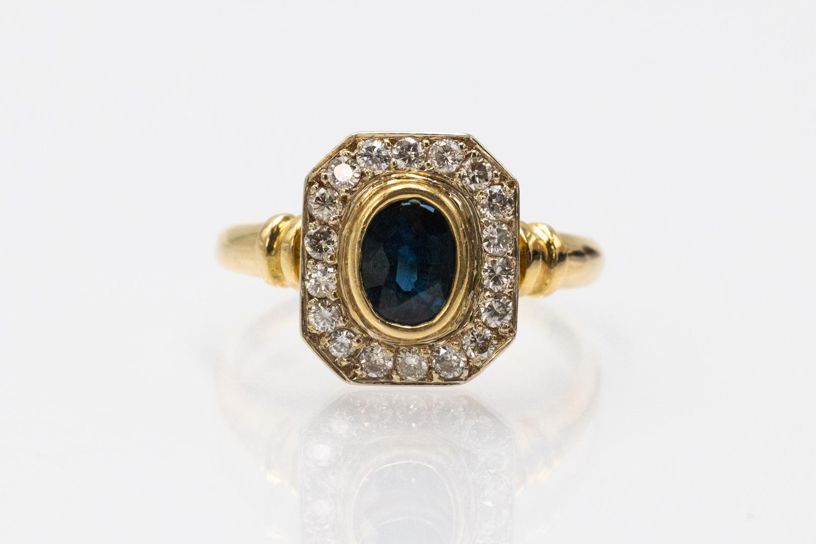 Bague géométrique unique en son genre, réalisée en or jaune 18 carats (titre 0,750). La bague en or est sertie d'un saphir naturel ovale central pesant environ 0,95 ct et de 18 diamants taille brillant totalisant environ 0,45 ct (couleur G-I, pureté