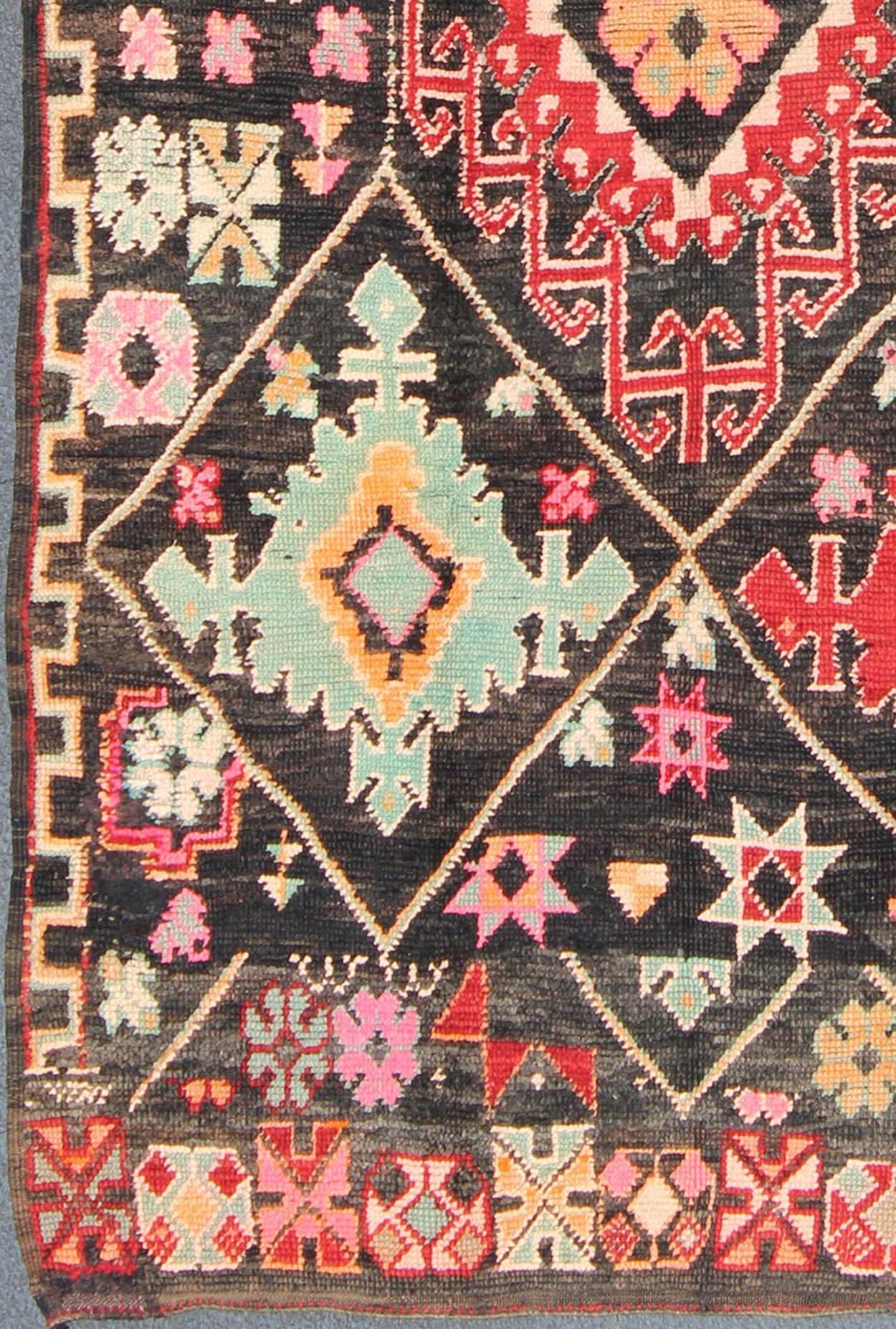 Geometric Vintage Moroccan Rug in Black, Red, Green 
With bold diamond and star medallions set on Black background, this unique Moroccan displays an array of unexpected colors. Set on a black background, the combination of rich colors and soft or