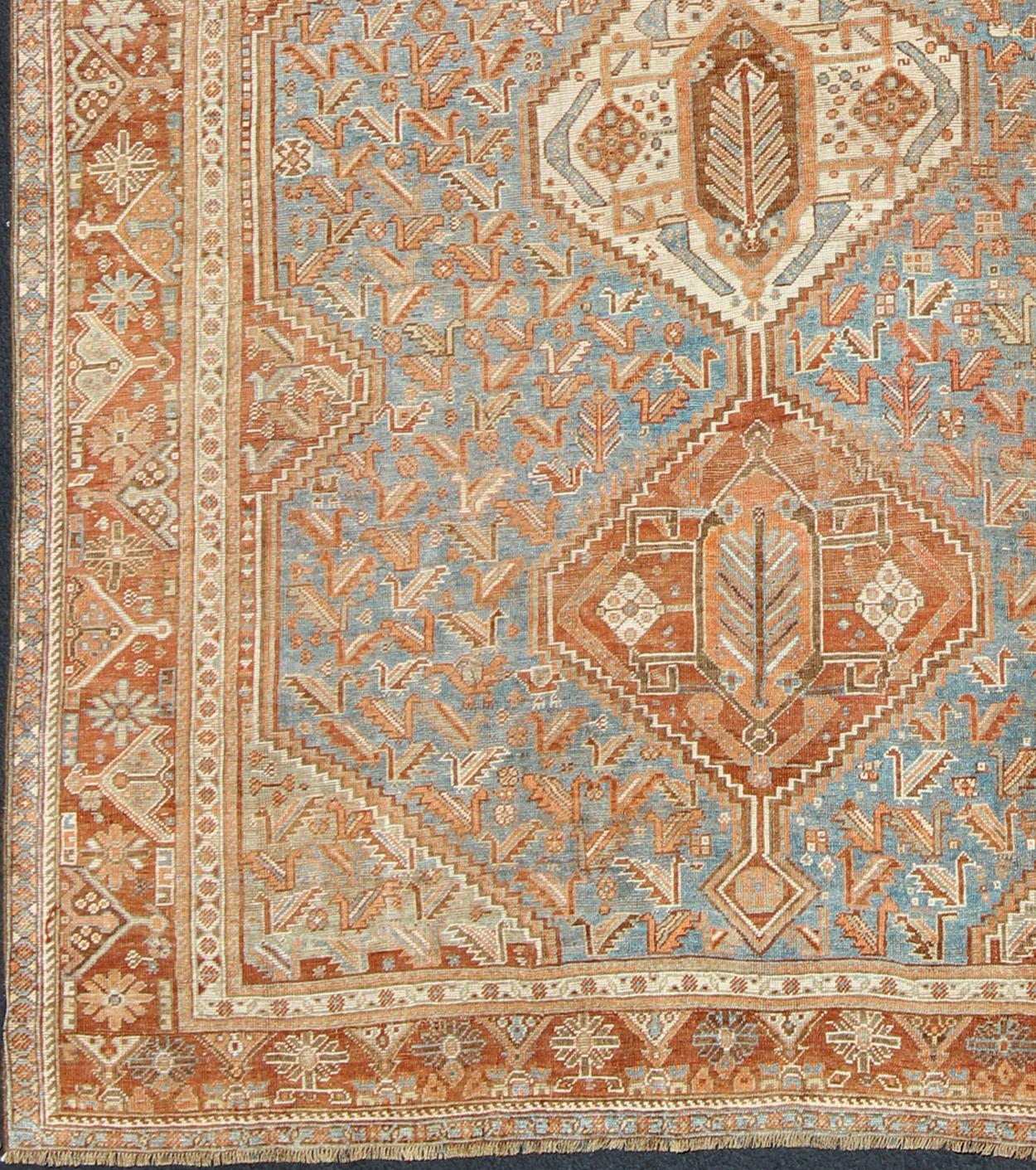 Persian vintage Shiraz carpet in red and blue with geometric medallions, rug ema-7552, country of origin / type: Iran / Shiraz, circa 1930.

This vintage Persian Shiraz rug (circa early 20th century) features a unique blend of colors and an