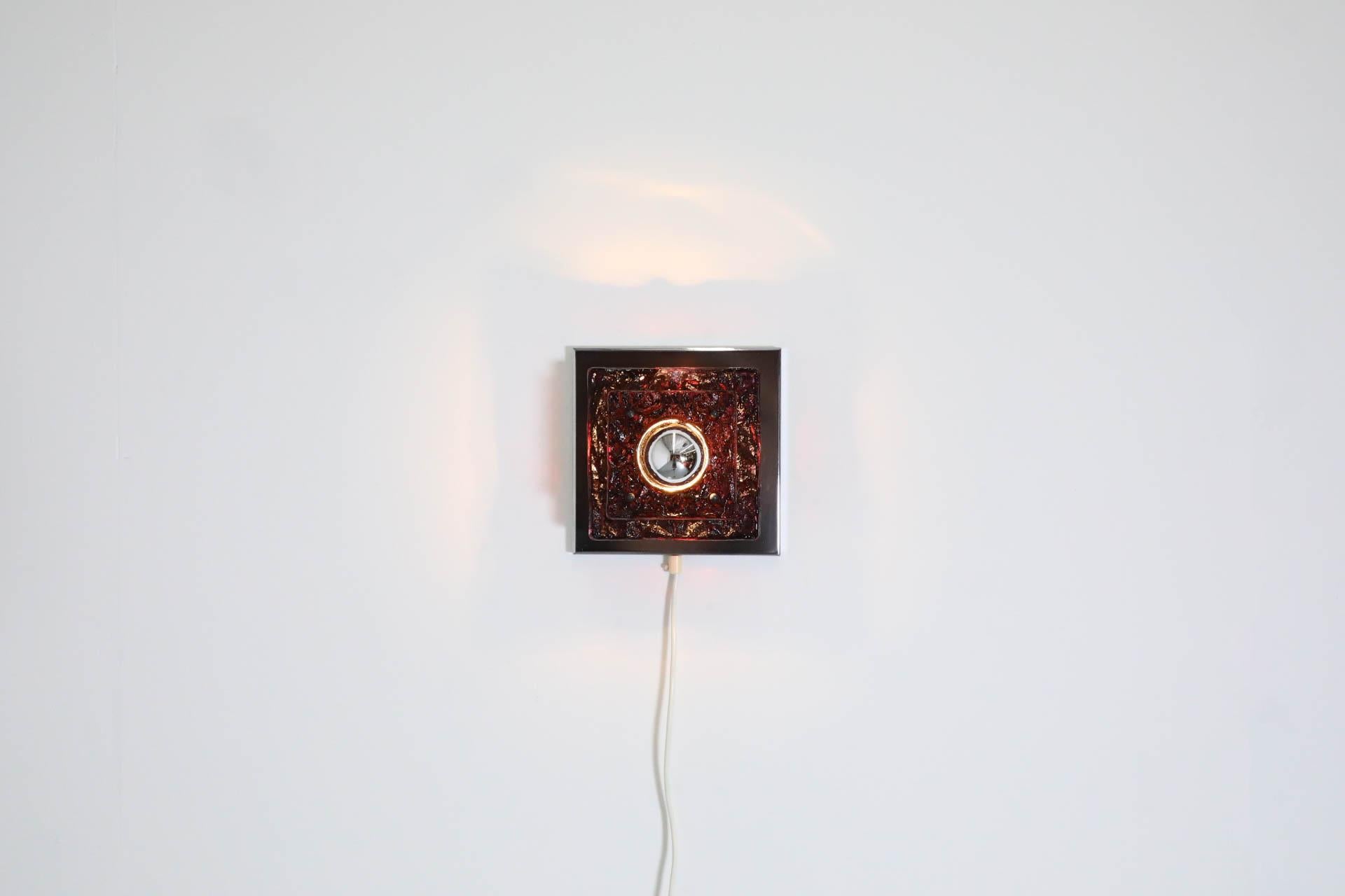 Mid-Century, geometric wall or ceiling sconce with graduated layers of amethyst glass and a center hole cut-out for the bulb. Frame is chrome with aluminum spacers and gray plastic caps. In original condition with minimal wear, consistent with it's