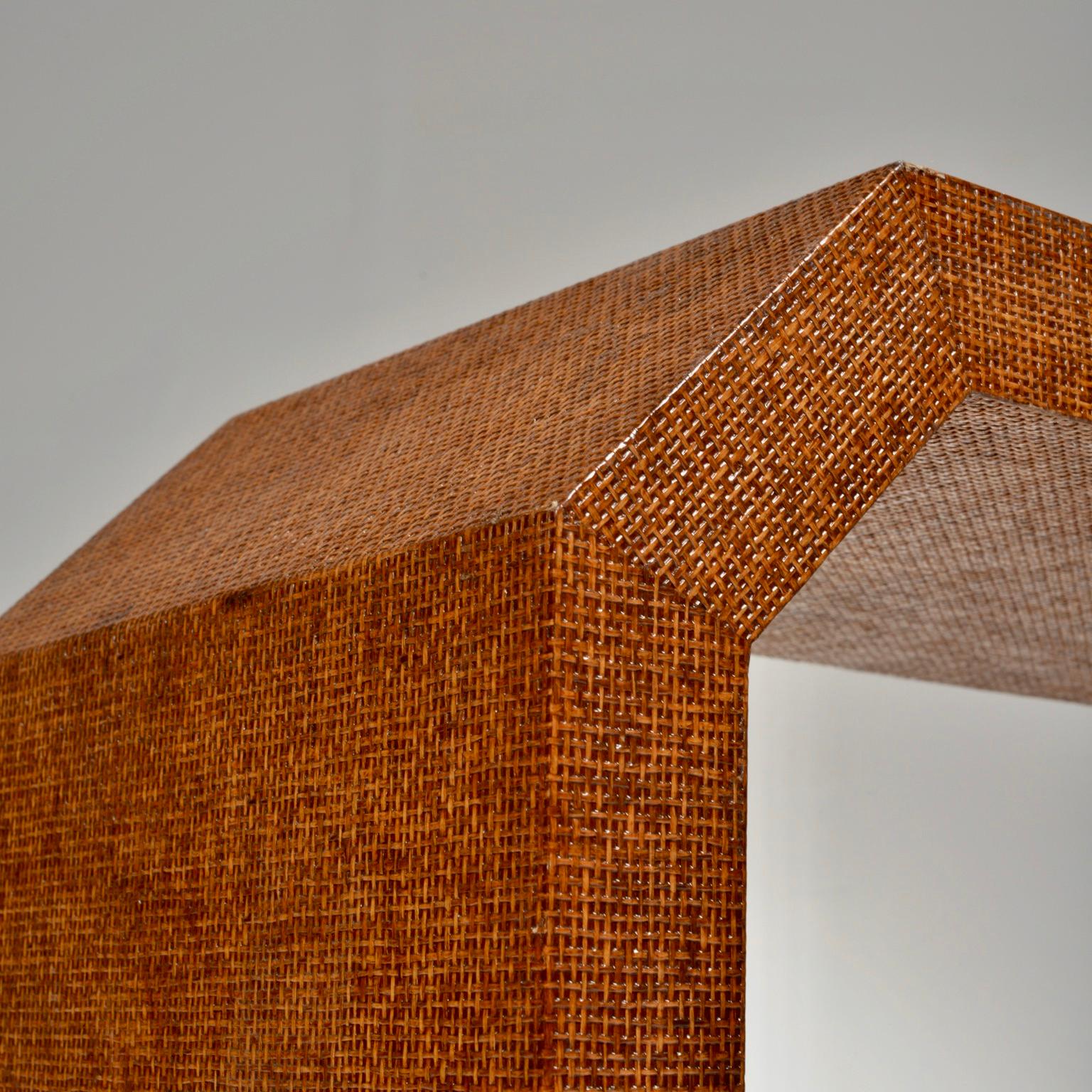 A geometric waterfall console table, wrapped in woven rattan, in the manner of Karl Springer or Enrique Garcel.




     