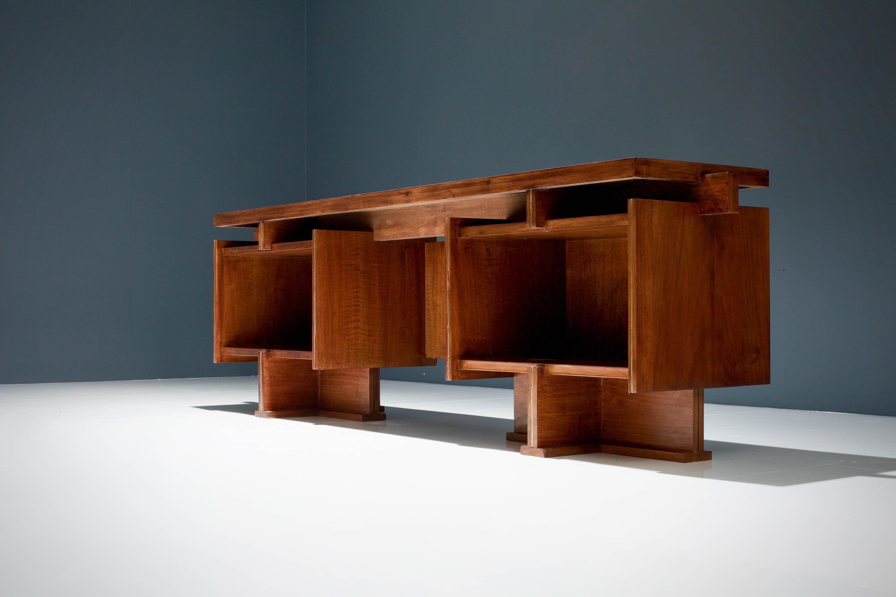Dieser geometrische Schreibtisch hat eine elegante Symmetrie. Dieser besteht aus zwei großen, rechteckigen Ablagefächern und vier kleineren Fächern darüber. Zwischen den Fächern befindet sich ein offener Raum, der für einen Stuhl vorgesehen ist.