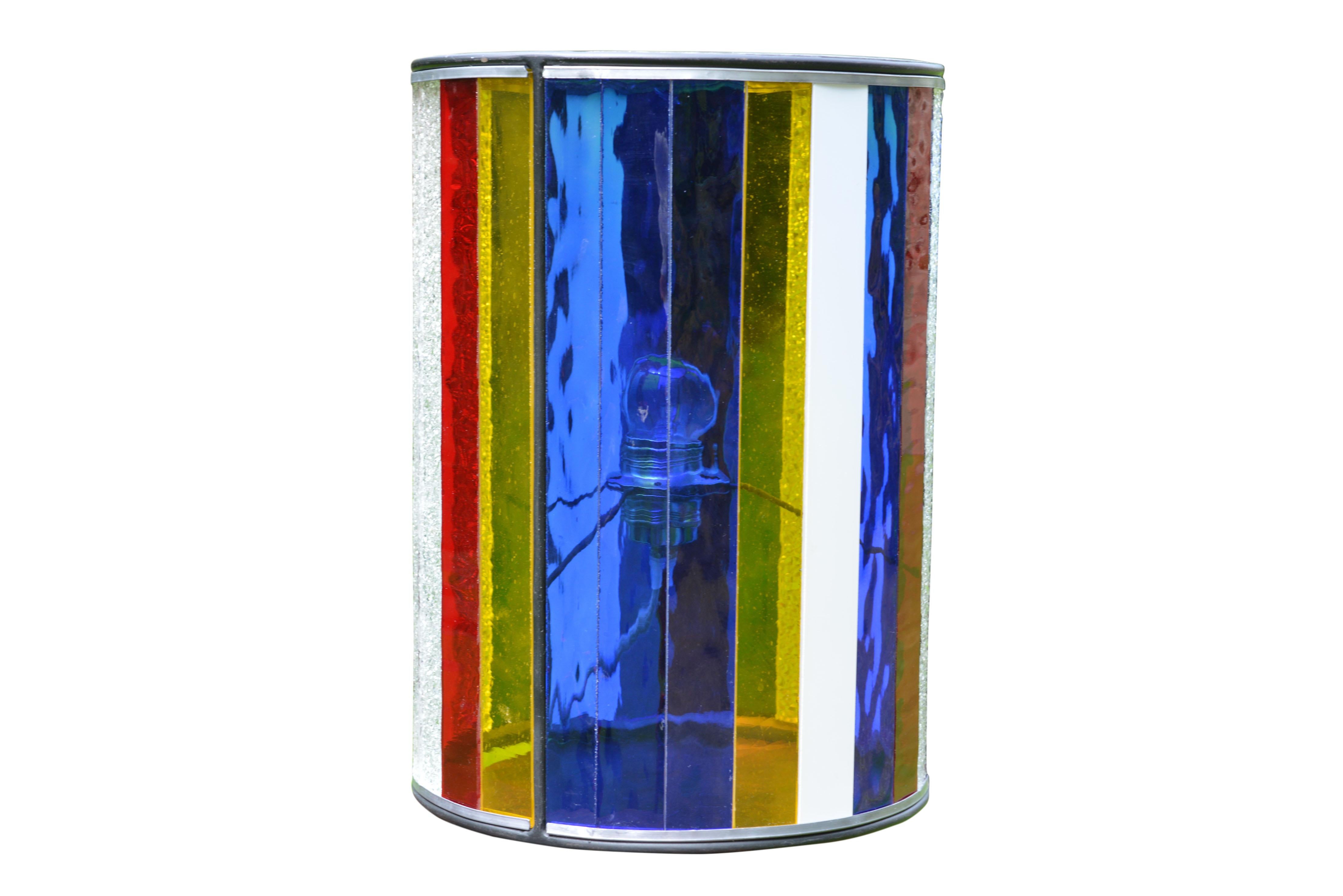 These funky disco-is table lamps were made in Bruges by two local artists, a metal and a glass artisan. This one is of cylindrical shape and has different colors and types of lead glass inserts.
    