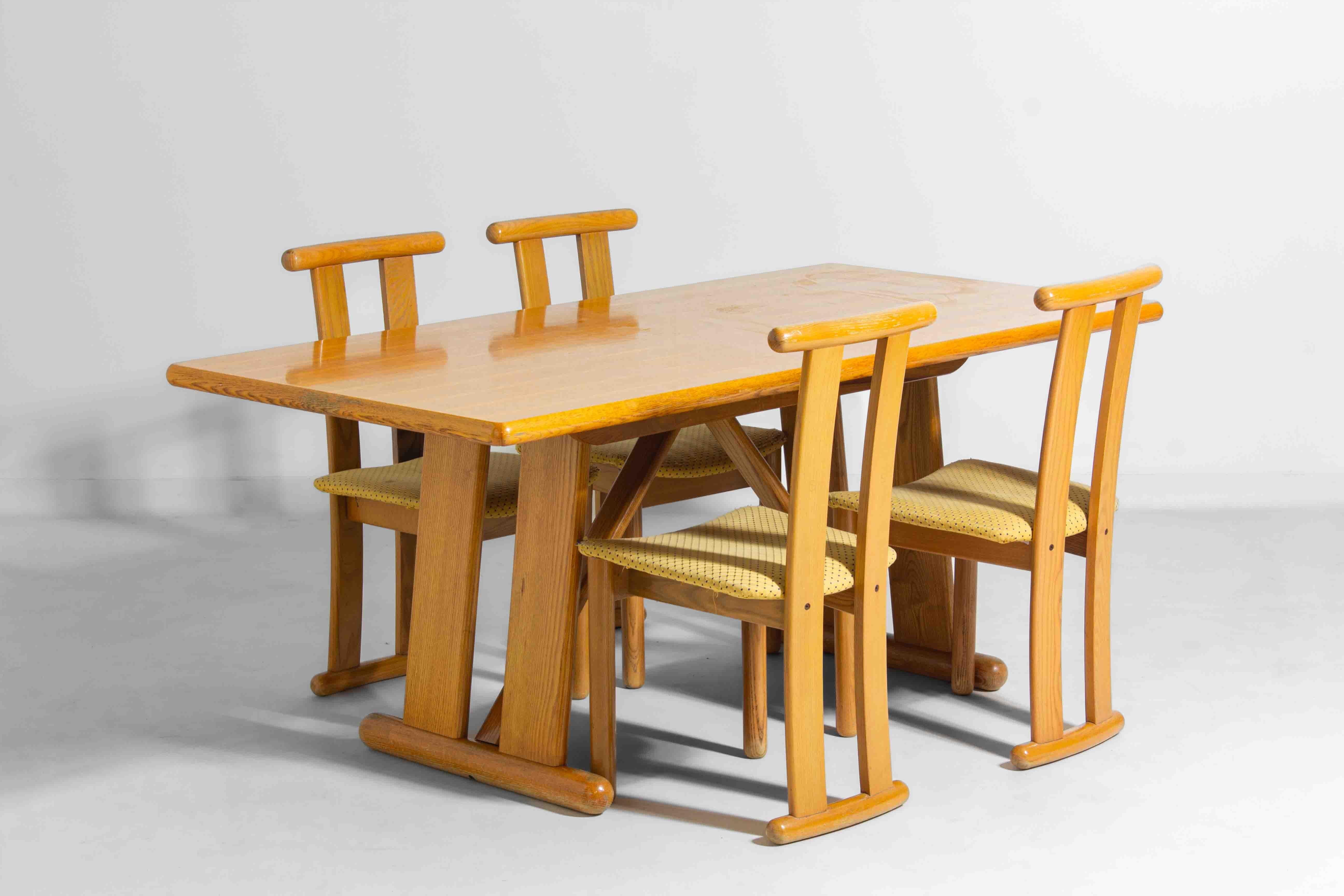 Questo tavolo da pranzo italiano degli anni '80 è realizzato in legno massiccio di quercia e presenta un design audace e geometrico. Le gambe angolate e i supporti triangolari gli conferiscono un aspetto forte e architettonico, mentre i bordi