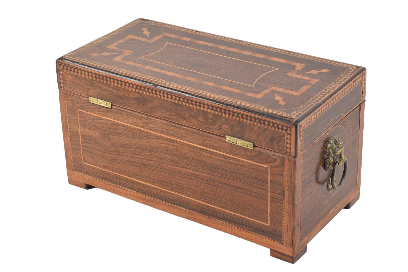 Raffinato porta tè a doppia camera in legno di palissandro George III con intarsi geometrici di ispirazione classica di legni esotici, tra cui satinwood, mogano, kingwood e palma. La cassa rettangolare con maniglie a testa di leone ai lati, un foro