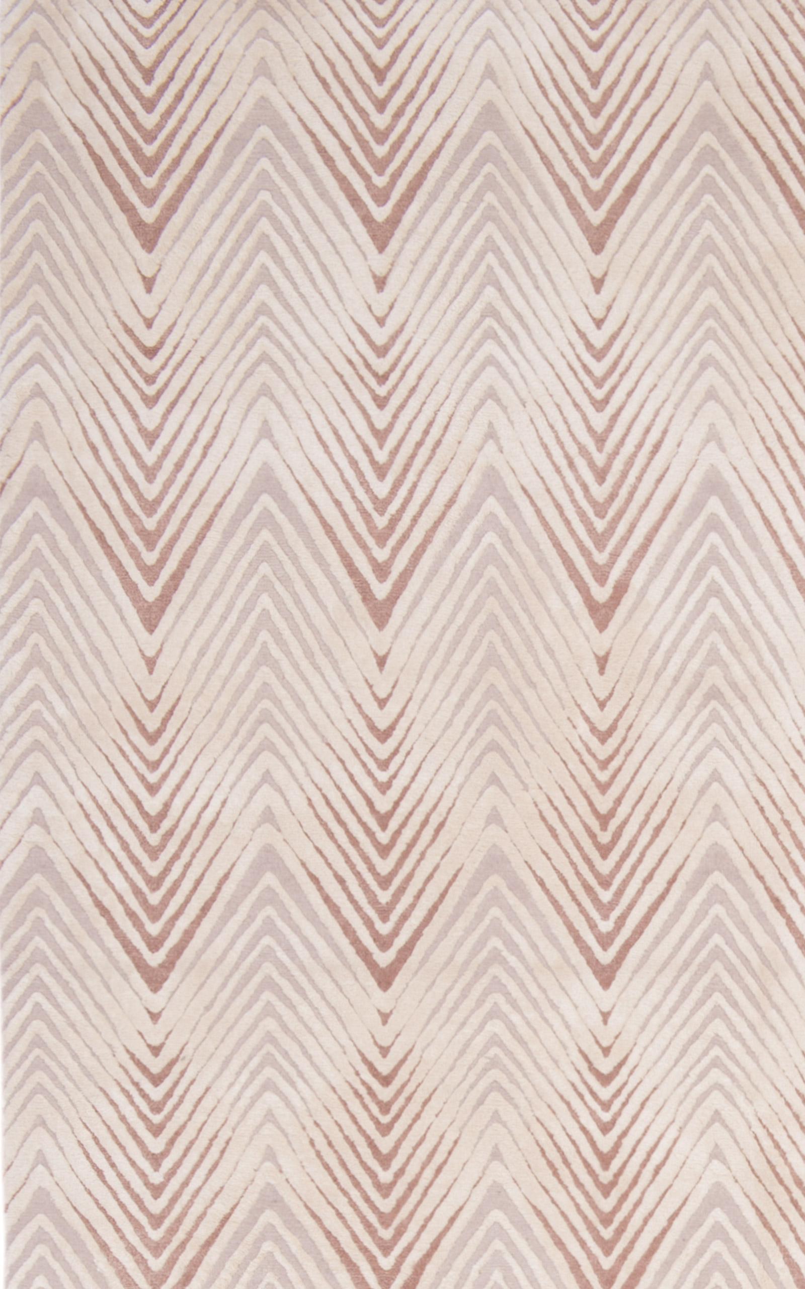Unser Teppich Diamond Stripe ist in zwei verschiedenen Florhöhen gewebt und hat ein geometrisches Muster mit einem niedrigeren Wollflor und einem leicht erhöhten Seidenflor. Dieser Kontrast verleiht dem Teppich Textur und Tiefe. Die Farbgebung Blush