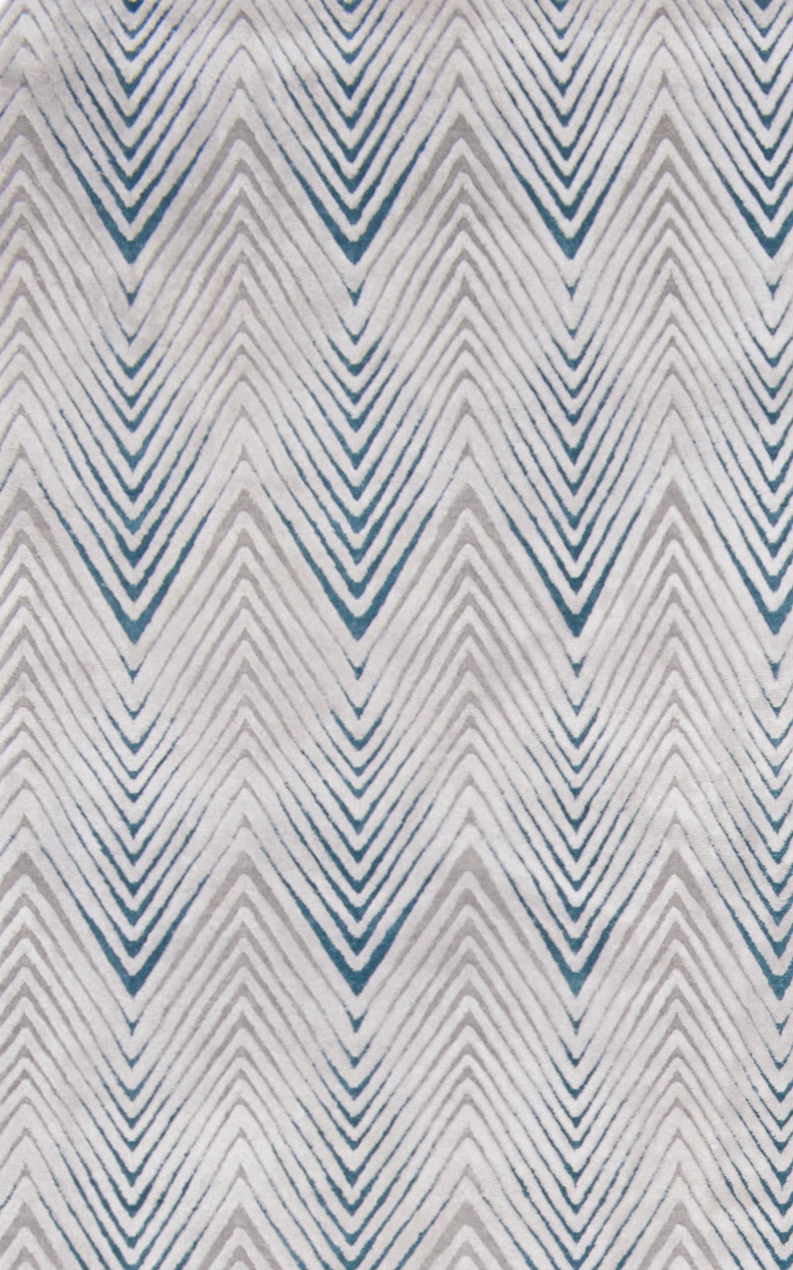 Unser Teppich Diamond Stripe ist in zwei verschiedenen Florhöhen gewebt und hat ein geometrisches Muster mit einem niedrigeren Wollflor und einem leicht erhöhten Seidenflor. Dieser Kontrast verleiht dem Teppich Textur und Tiefe. Die Farbgebung Blush