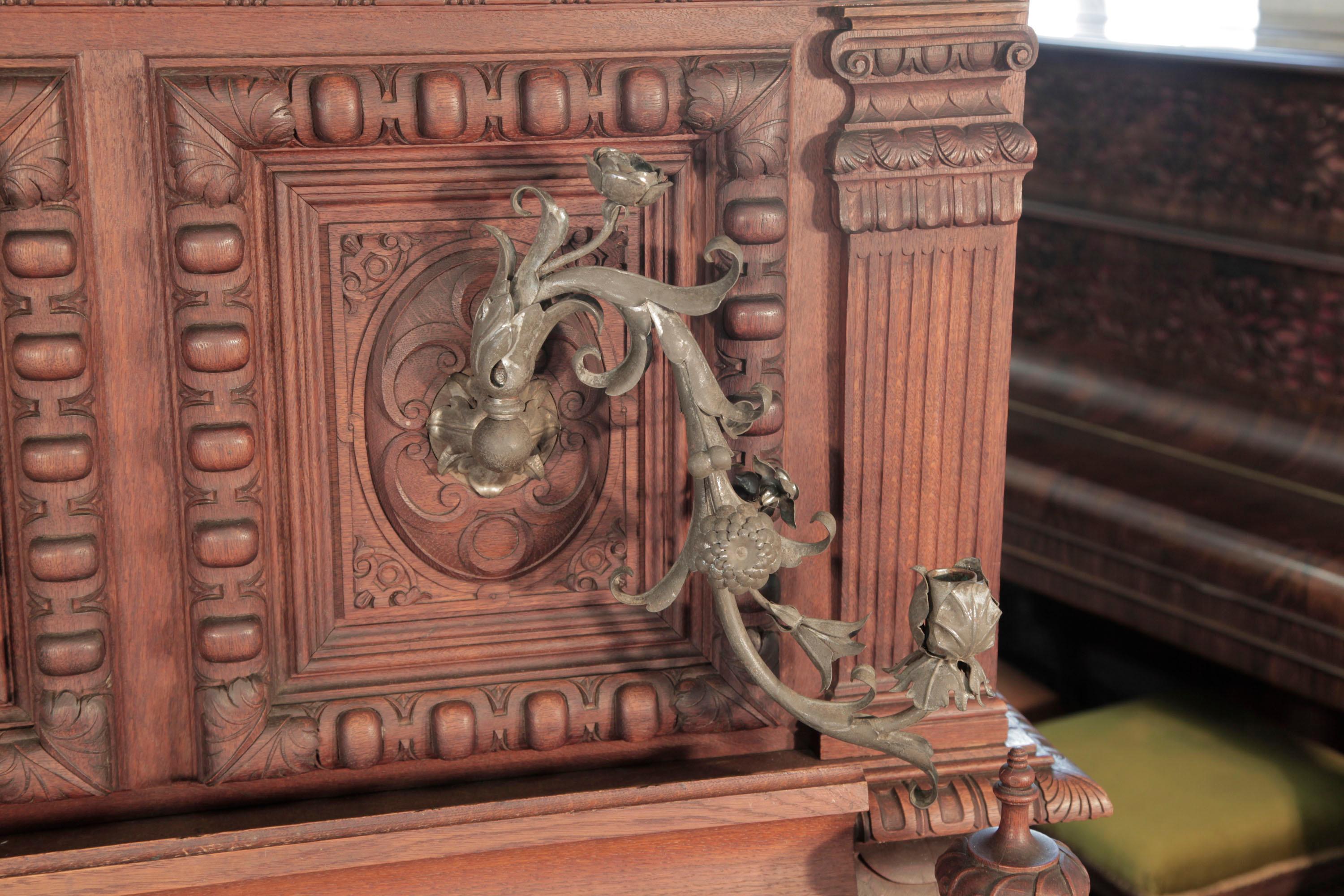 Antique, Georg Fortner upright piano for sale with an ornately carved, mahogany case and ornate candlesticks. Entire cabinet features carved flowers, foliage, musical instruments and grotesque heads on each piano cheek. 

This upright piano was