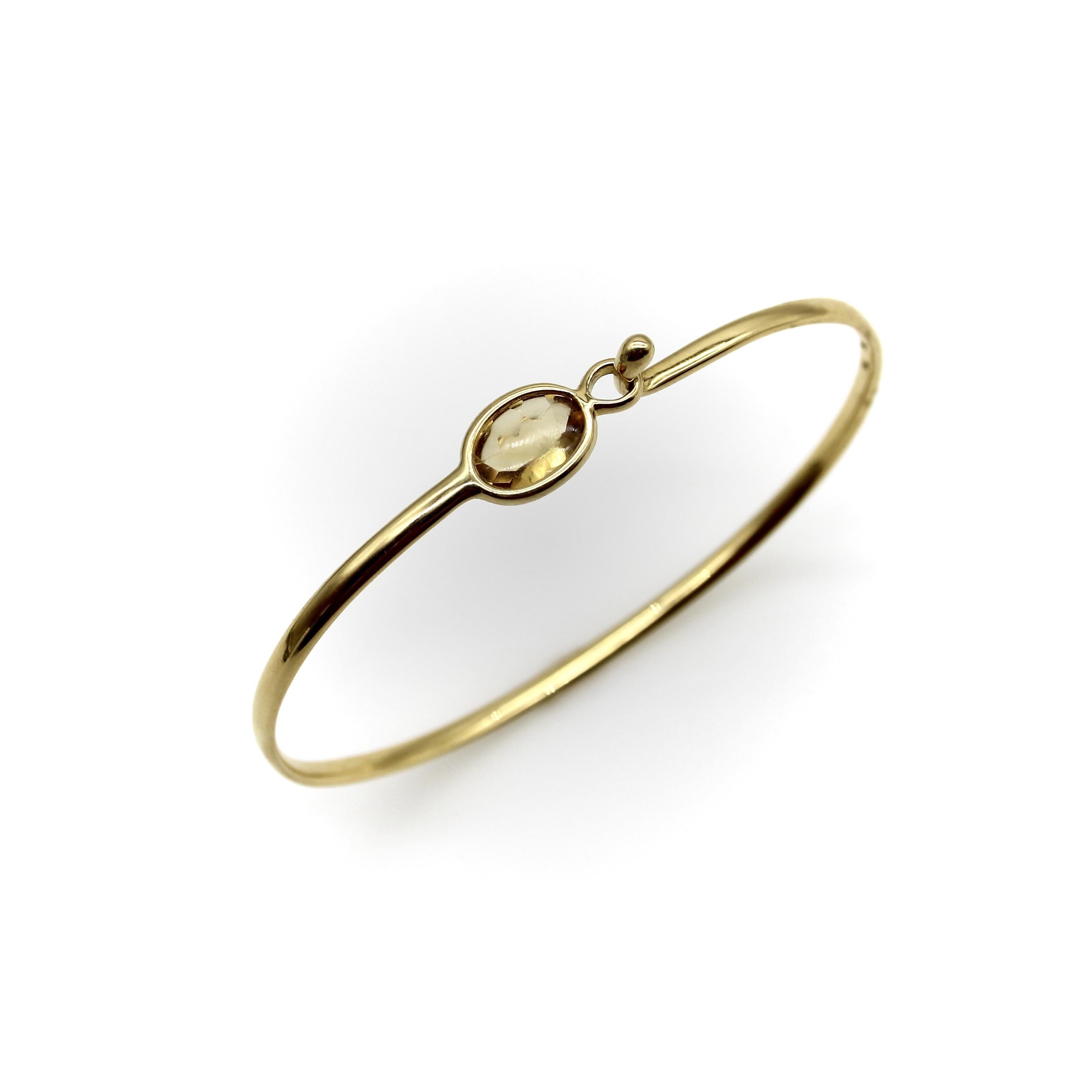 Georg Jensen is a Danish designer of jewelry and silver known for his distinctly modern take on form. This is his 18k gold Savannah bracelet, featuring a bezel set citrine and classic hook and eye closure. The citrine has a slight cabochon on the