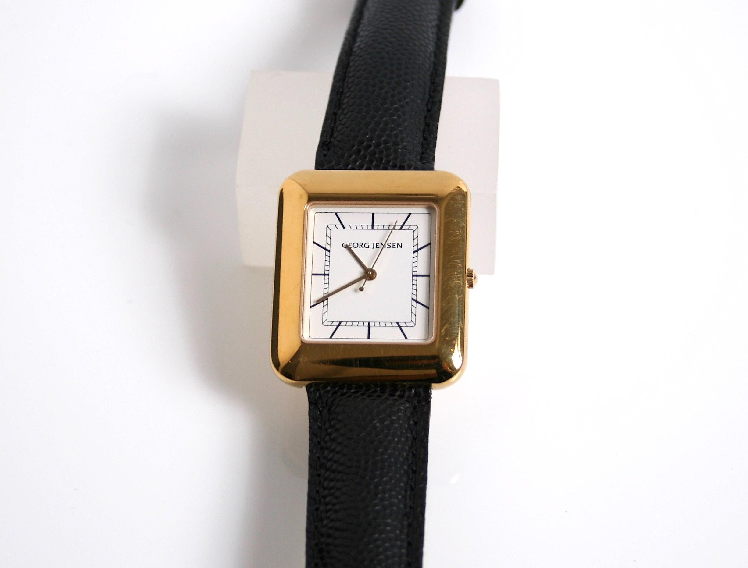 Rare Georg Jensen 18 Karat Gold vermeil quartz Watch Designed by Line Munth Denmark c1980
Crisp white face with black numerals with gold hands

Design number 354 comes in the original Jensen box
New old stock still has protective film on reverse