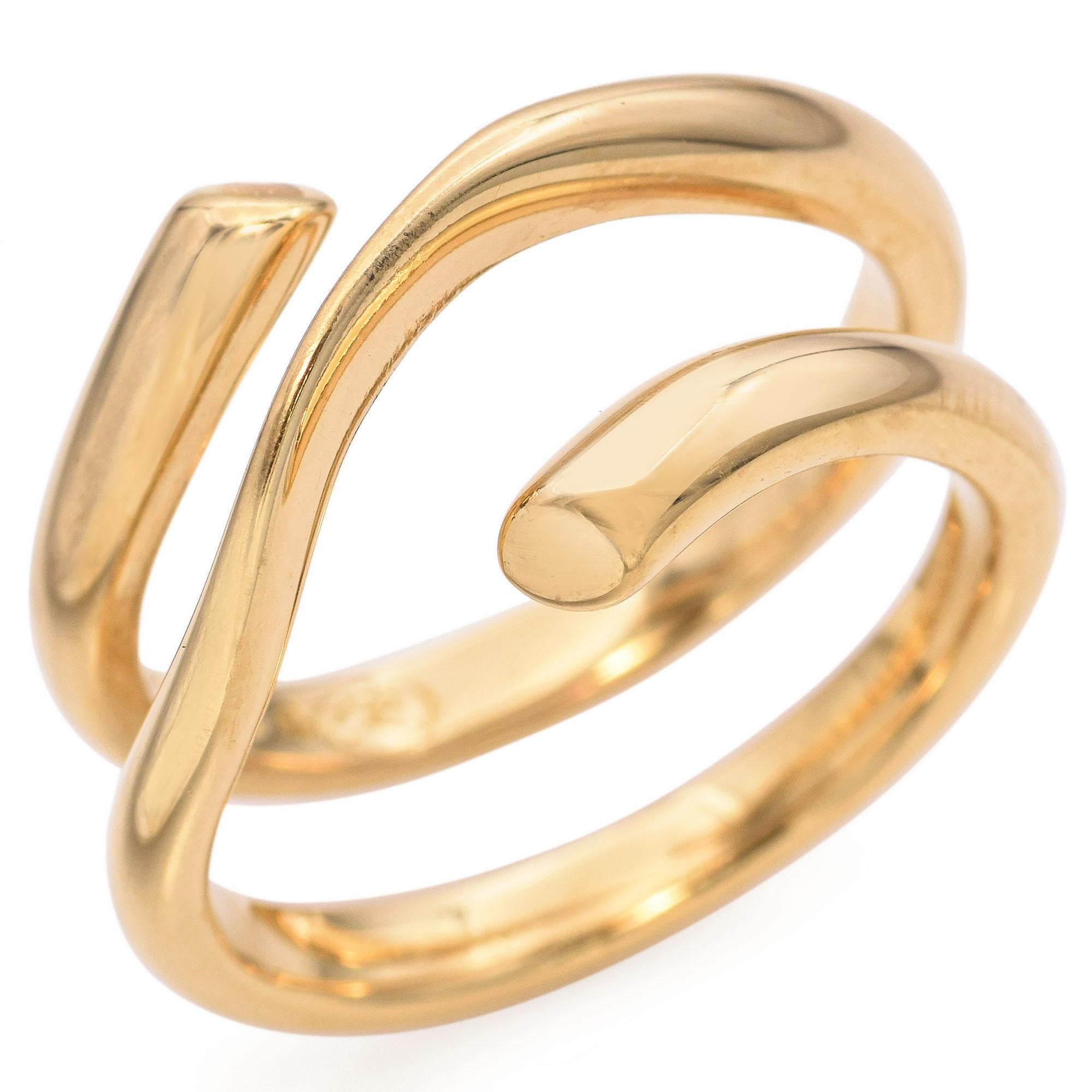 A sleek Georg Jensen gold wrap ring, featuring a fluid, open-ended design crafted in polished gold. The band elegantly curves and overlaps, creating a modern, minimalist aesthetic.

Weight: 9.4 grams 
Measurements: 12.5mm long
Ring