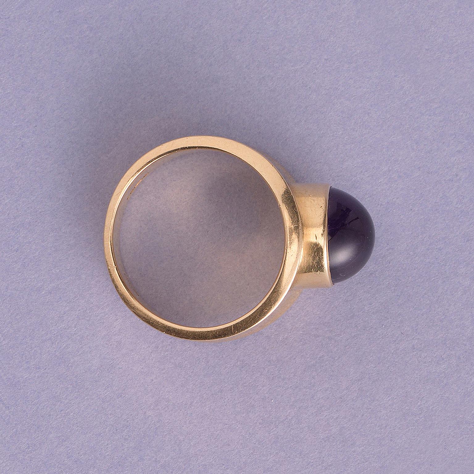 An 18 carat yellow gold band ring set with a cabochon cut amethyst, signed and numbered: Georg Jensen, 1124, Denmark, 1967. 

weight 9.86 grams
width: 2 cm
ring size: 16.75 mm / 6 1/4 US