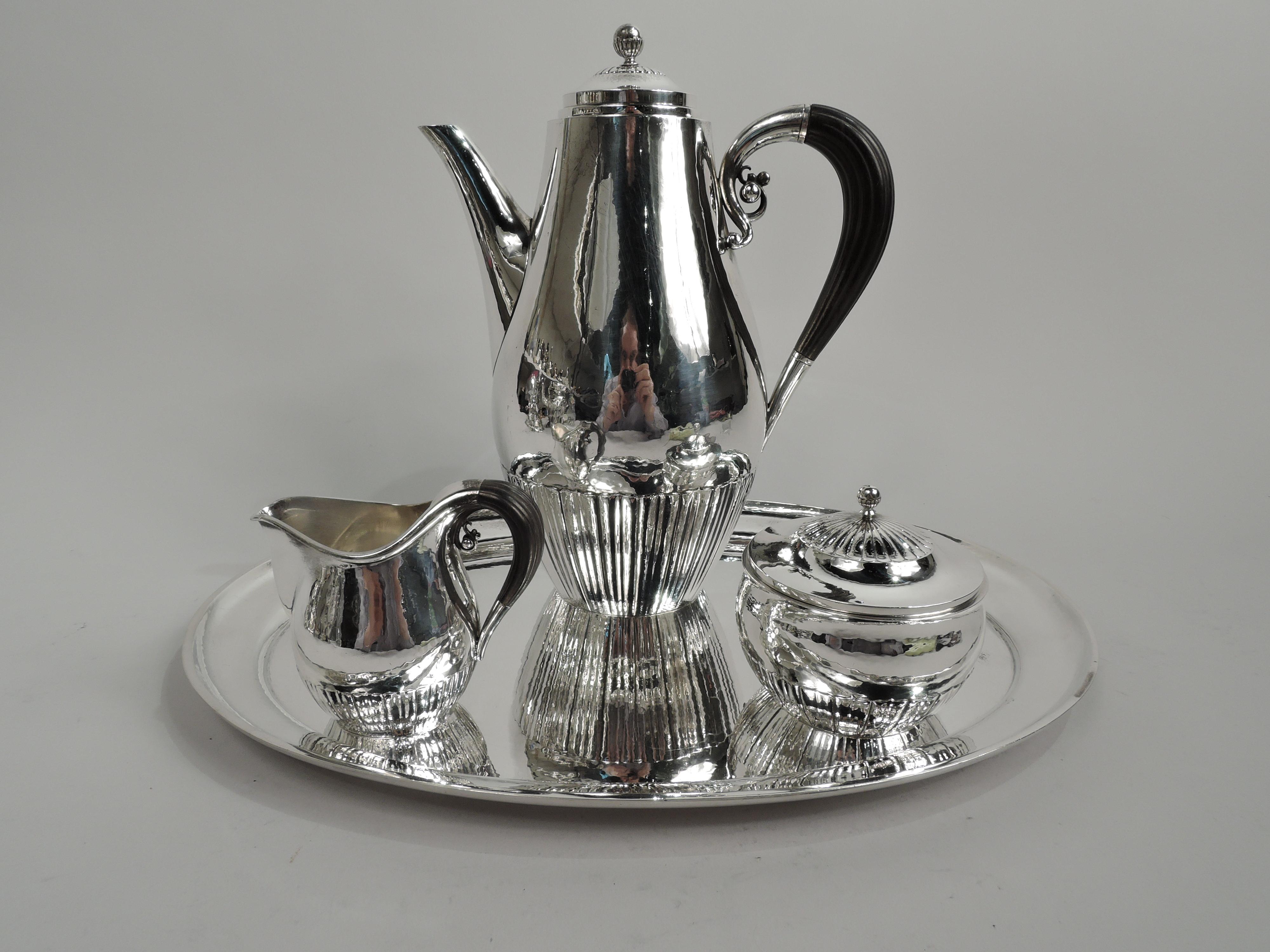 Cosmos sterling silver coffee set on tray. Made by Georg Jensen in Copenhagen. This set comprises coffeepot, creamer, and sugar. Gently curved and half-fluted bodies. Coffeepot and creamer have reeded stained-wood high-looping handles with silver