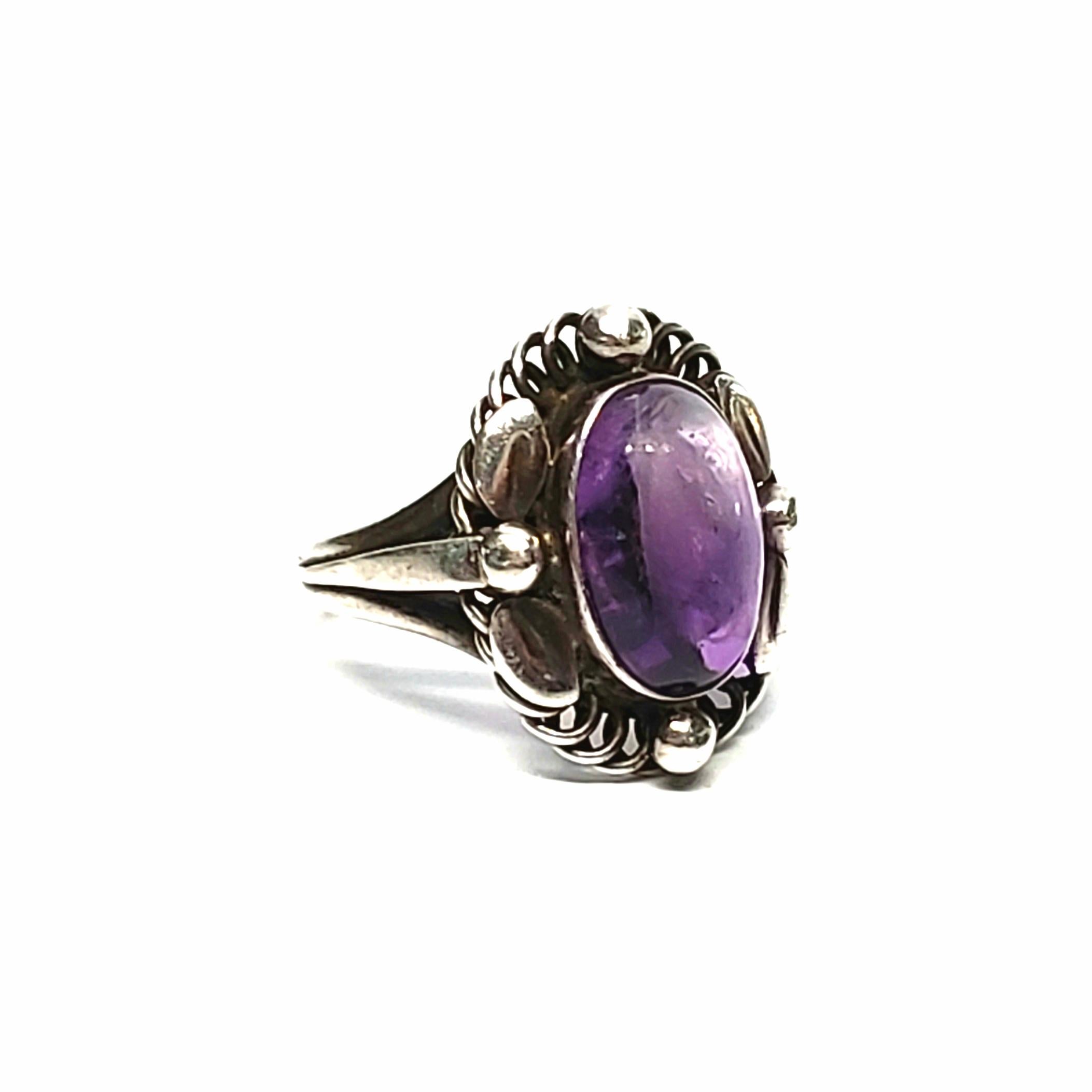 Vintage Georg Jensen 830 silver #1 amethyst ring, size 5.

This ring features a bezel set oval amethyst stone surrounded by a leaf and bead design. Circa 1915-30.

Measures 18mm x 15mm top, 12mm x 8mm stone, sits 7mm high.

Weighs 4.2g,