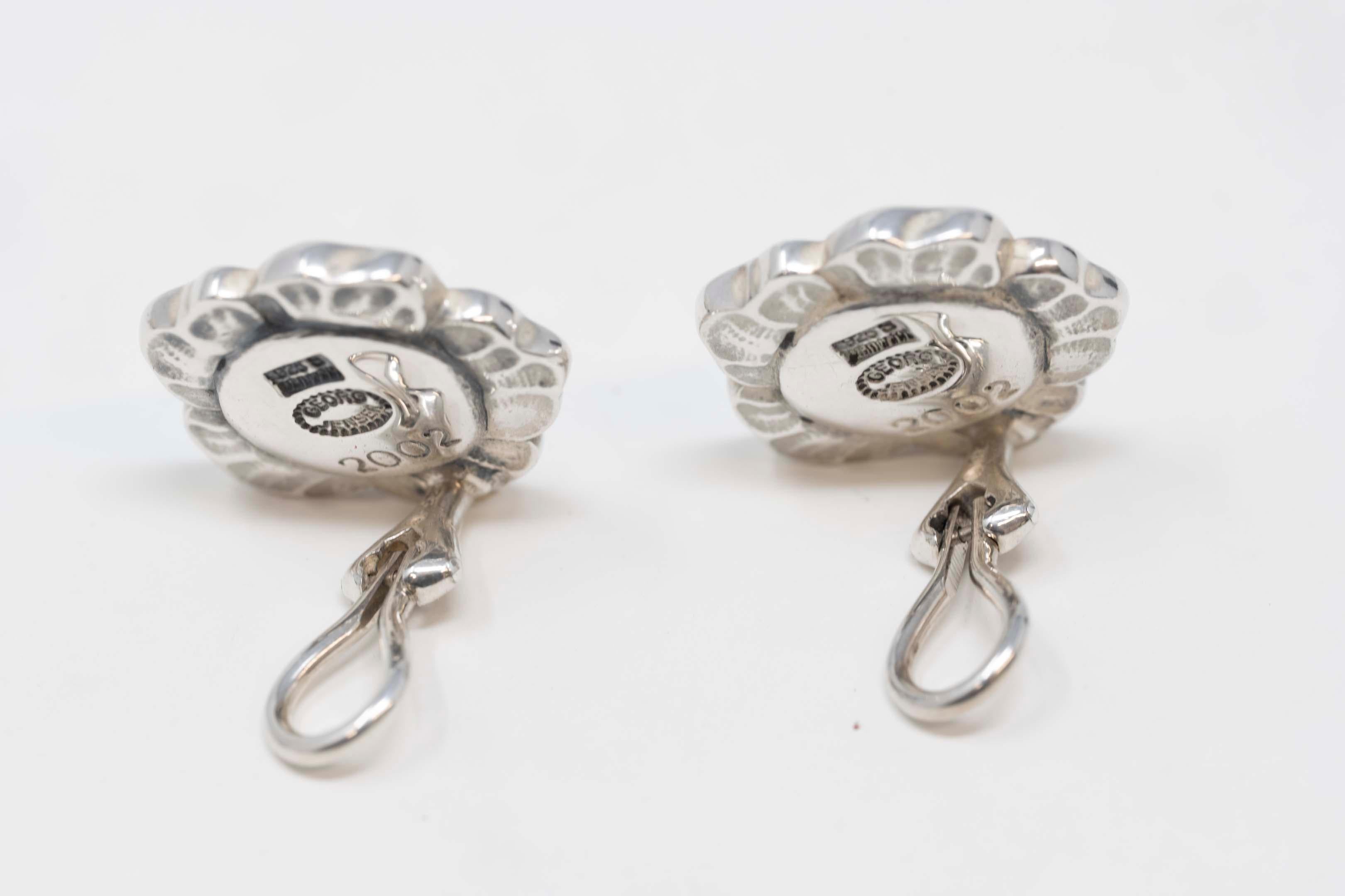 Georg Jensen Denmark 925 silver earring set numbered 2002. Stamped on the back, flower design with omega clip on. 14mm diameter, 20th century Denmark. In good condition.
