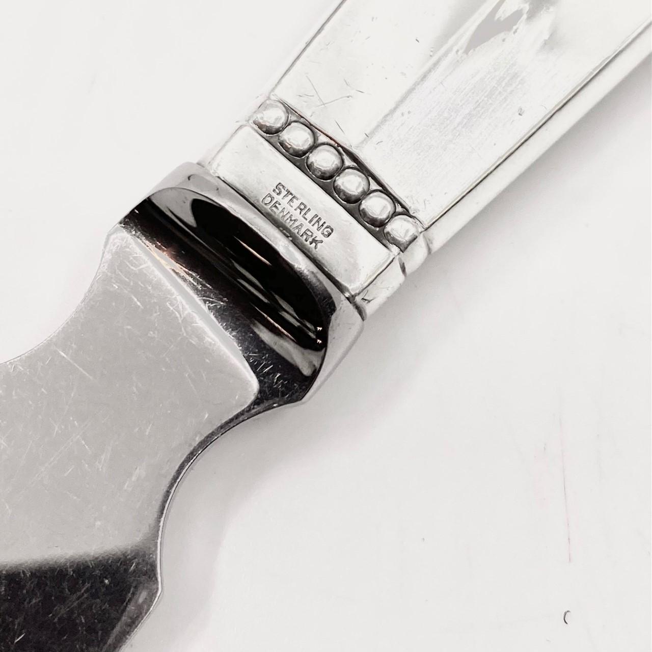 Sterling silver handle and stainless steel (blade) Georg Jensen cake knife, item #196 in the Acanthus pattern, design #180 by Johan Rohde from 1917.

Georg Jensen changed the design of the blade in the 1930’s, this is the old type blade.

Additional