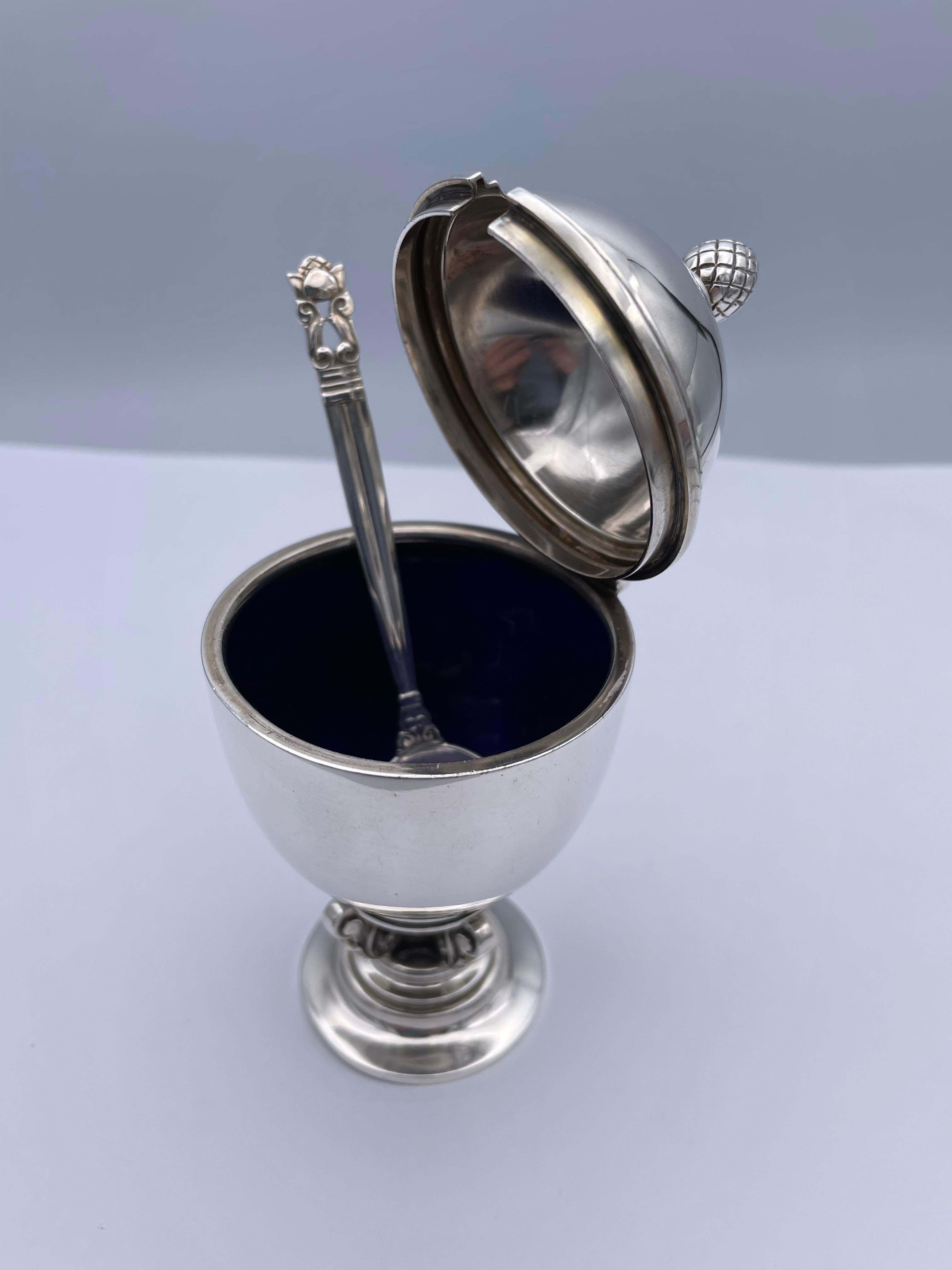 Acorn pattern hinged mustard pot with spoon.  Made by GEORG JENSN.  Sterling silver, with original cobalt glass liner.  4 1/2